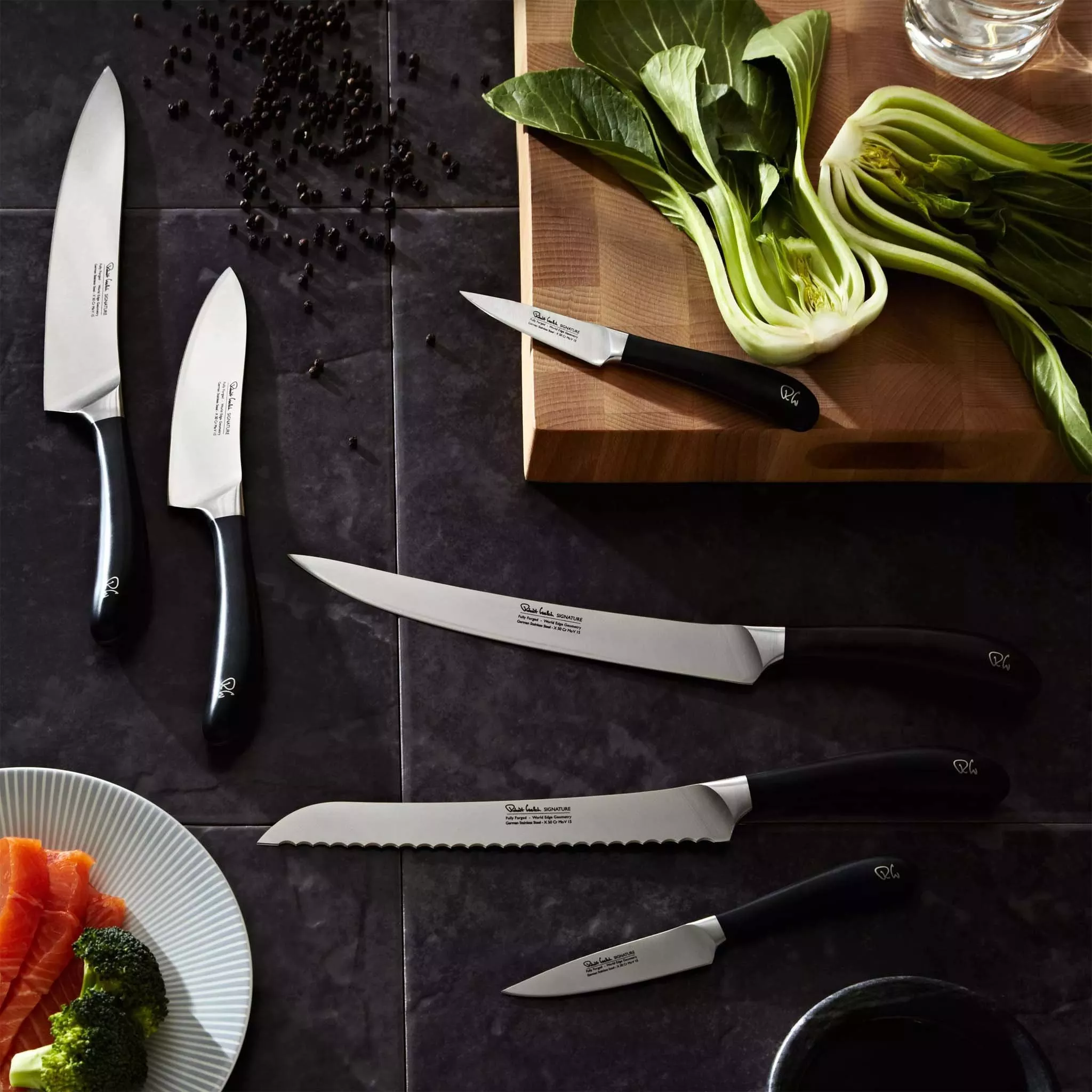 Selection of silver kitchen knives with black handle on a kitchen counter