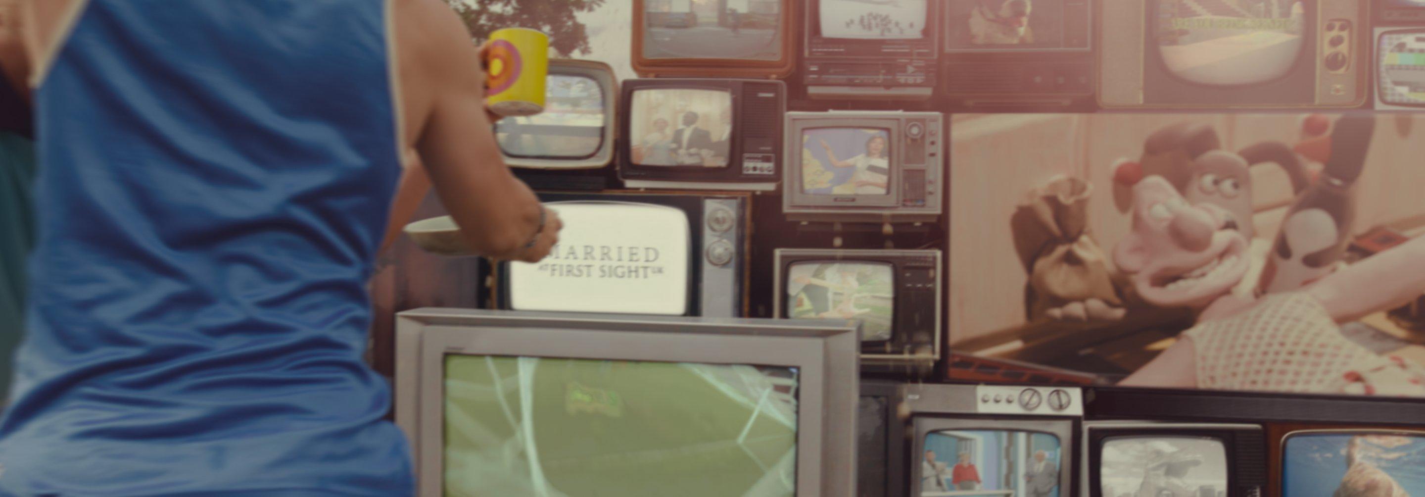 a stack of old tv's with modern shows on them