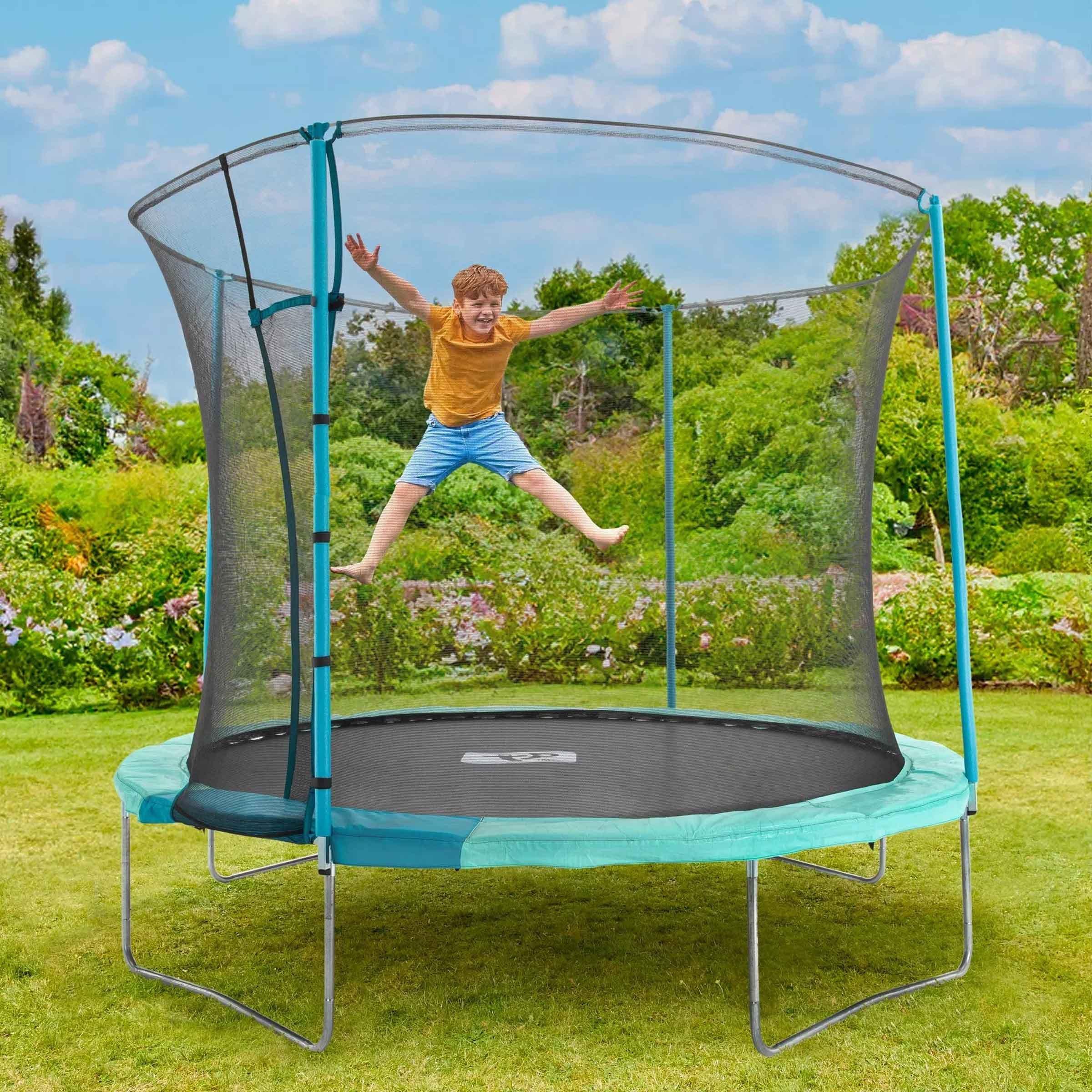 Boy on trampoline in green garden