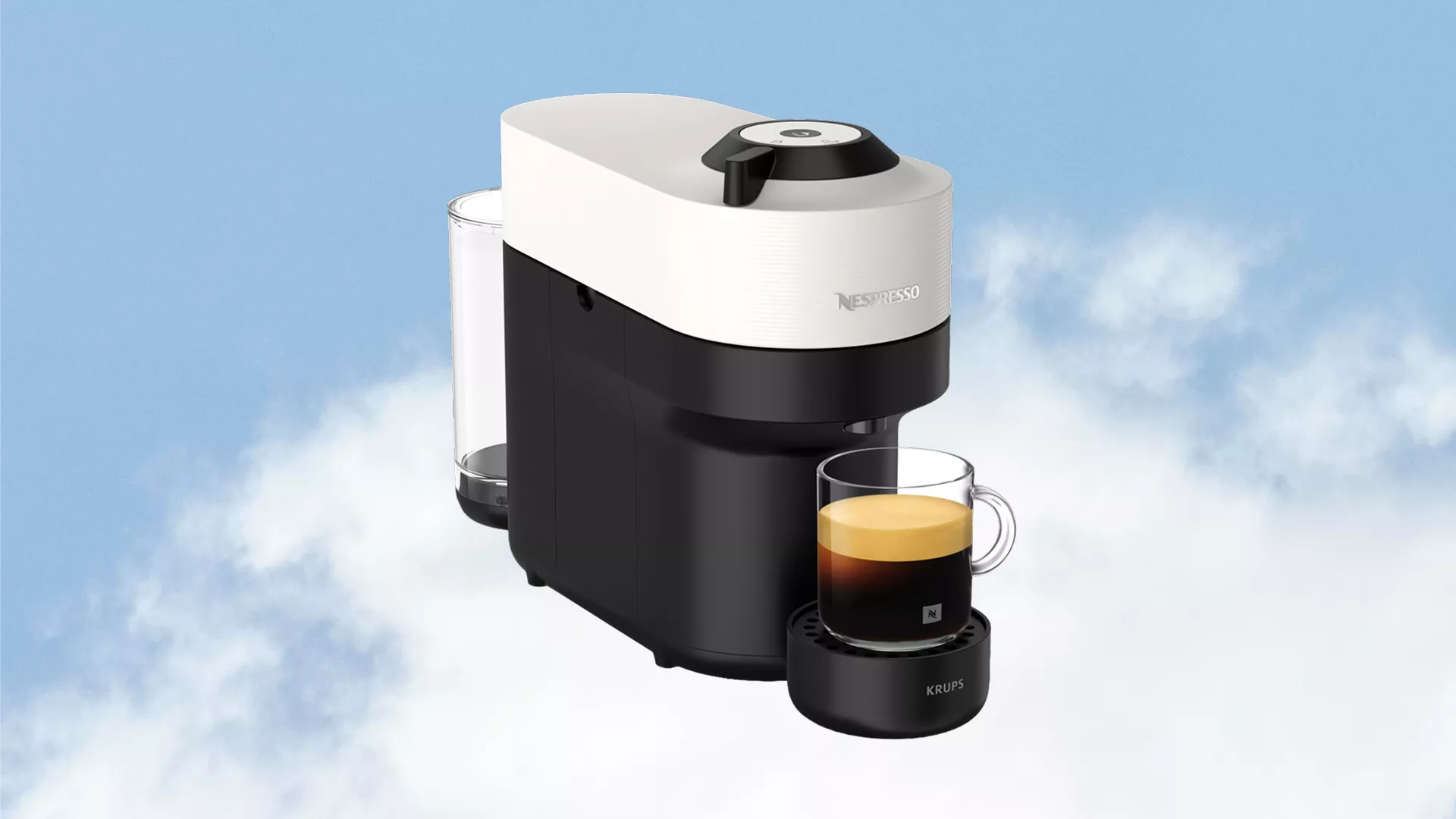 Nespresso Krups coffee machine with water tank, brewing espresso into a glass cup on drip tray, blue sky backdrop