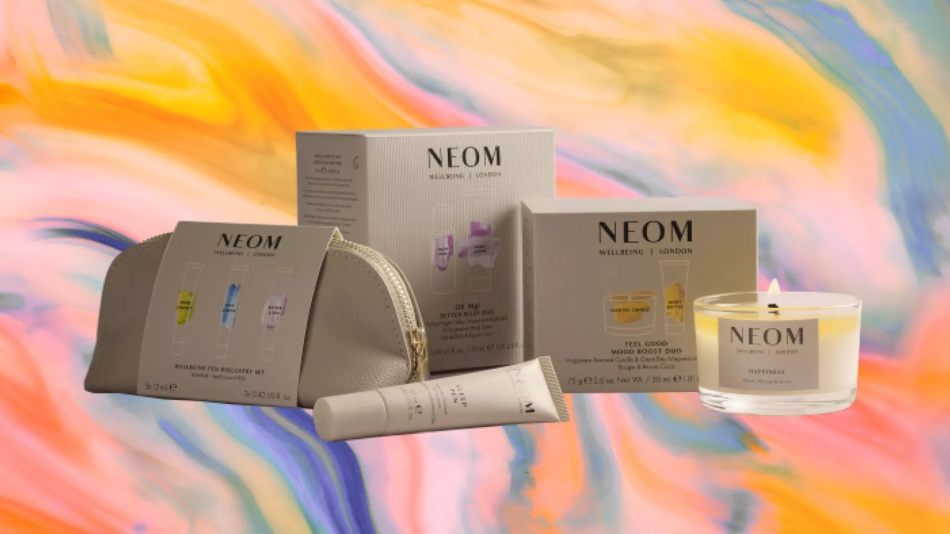 NEOM Wellbeing products displayed against a vibrant, colourful background, featuring a candle and gift sets.