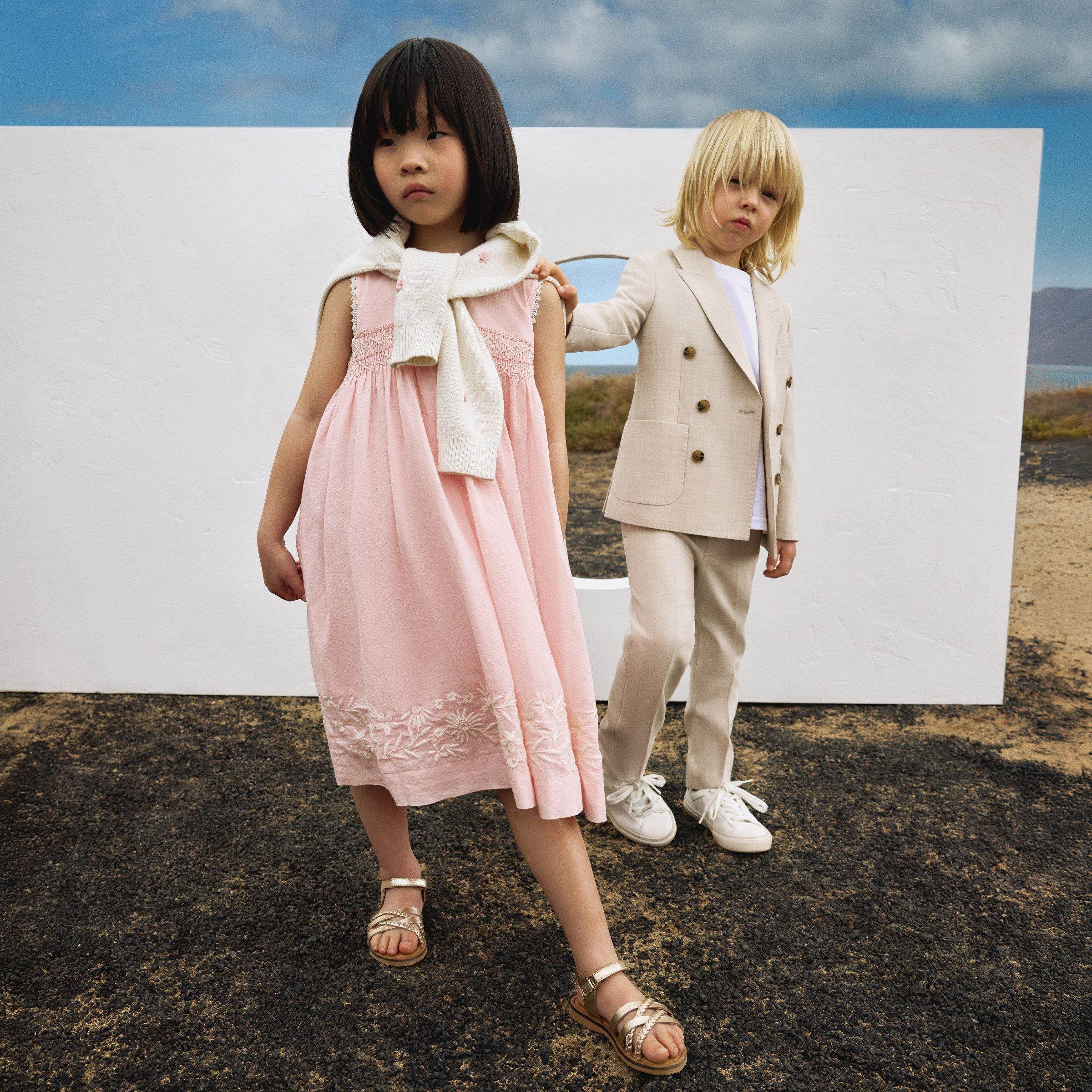 girl and boy dressed in smart ataire in a sunny rocky background