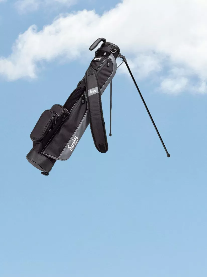 Black Sunday Golf lightweight stand bag with dual shoulder strap and pockets against a blue sky background