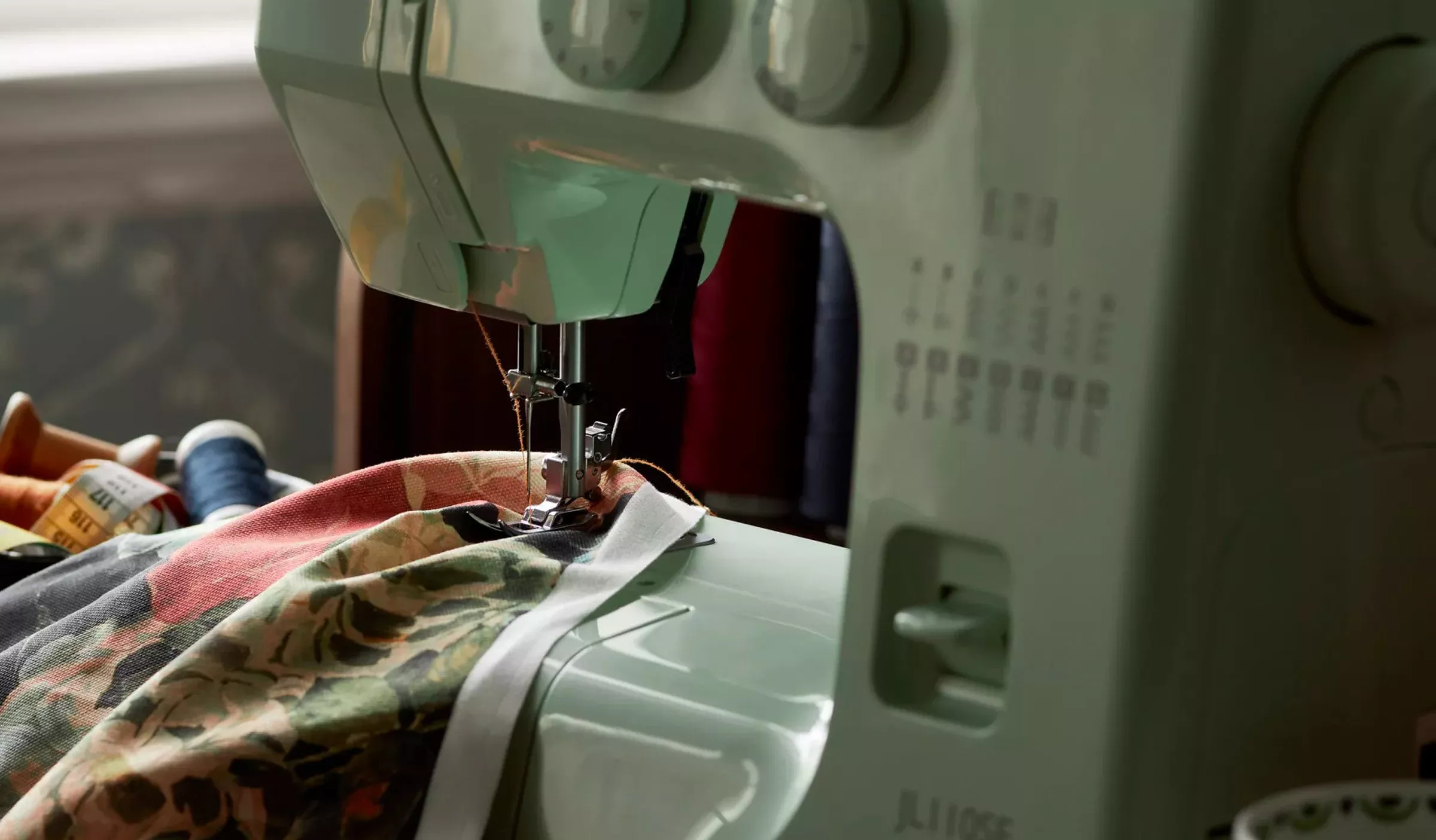 Sewing machine with colourful fabric being hemmed
