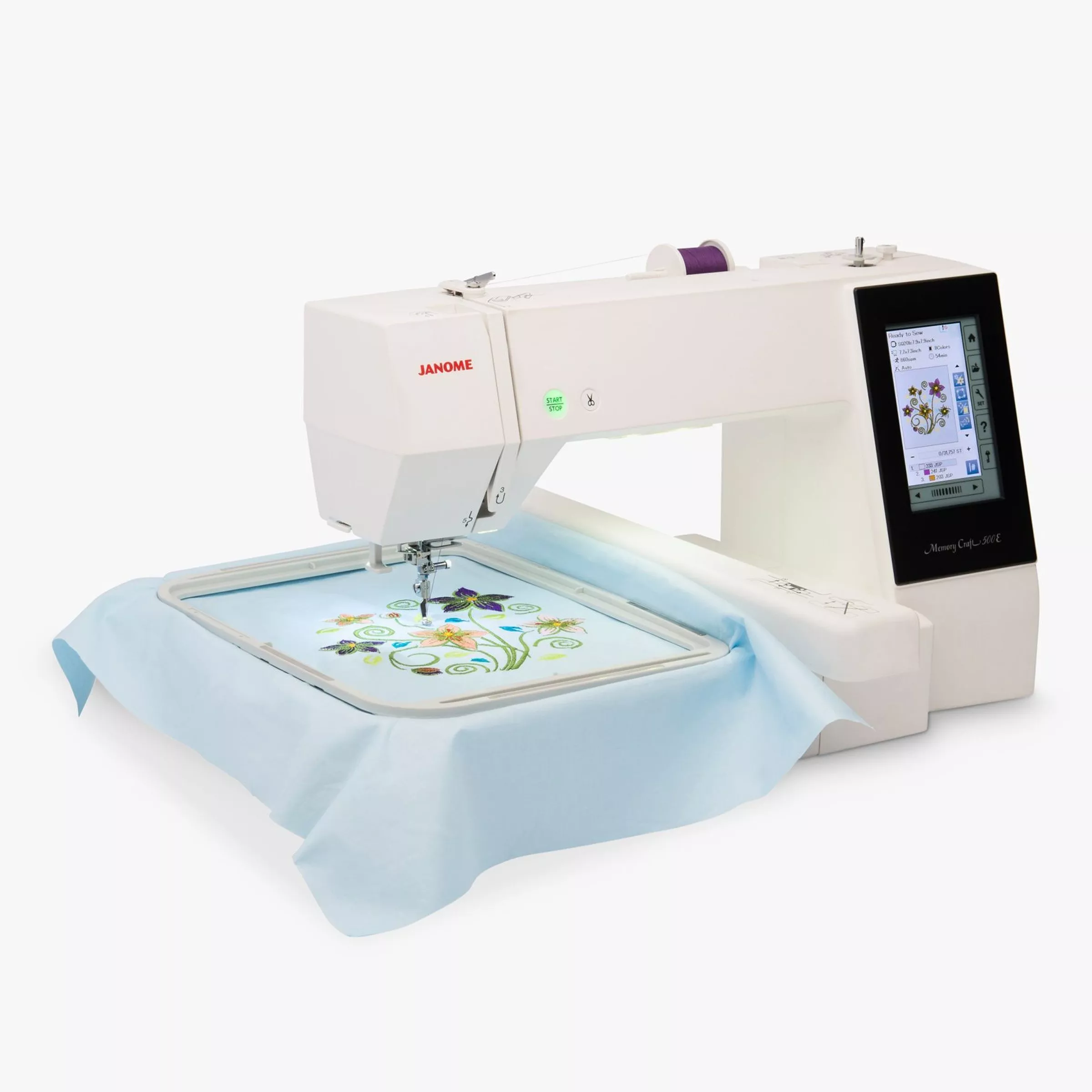 White sewing machine sewing a floral pattern onto blue fabric