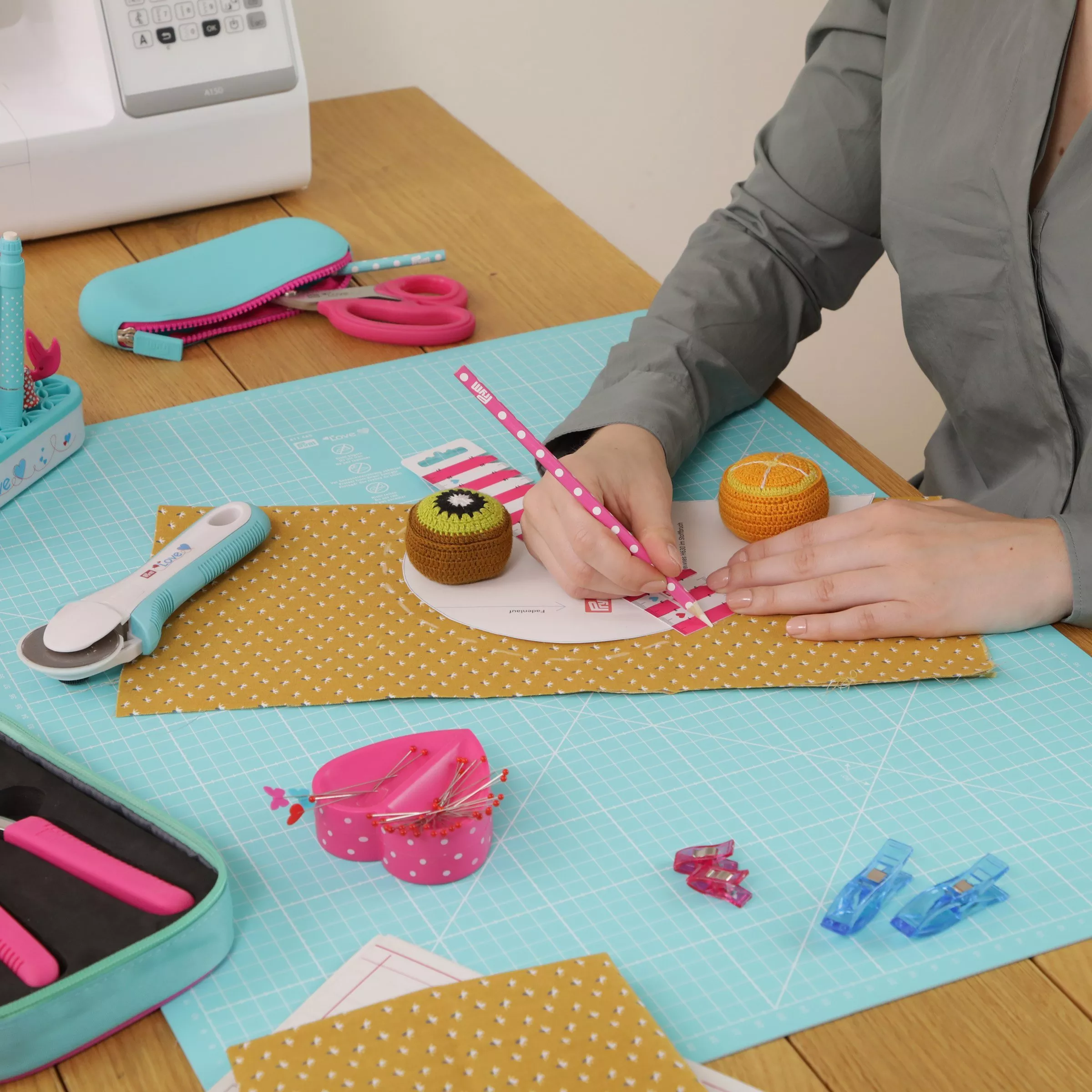 A person measuring out fabric on a cutting board 