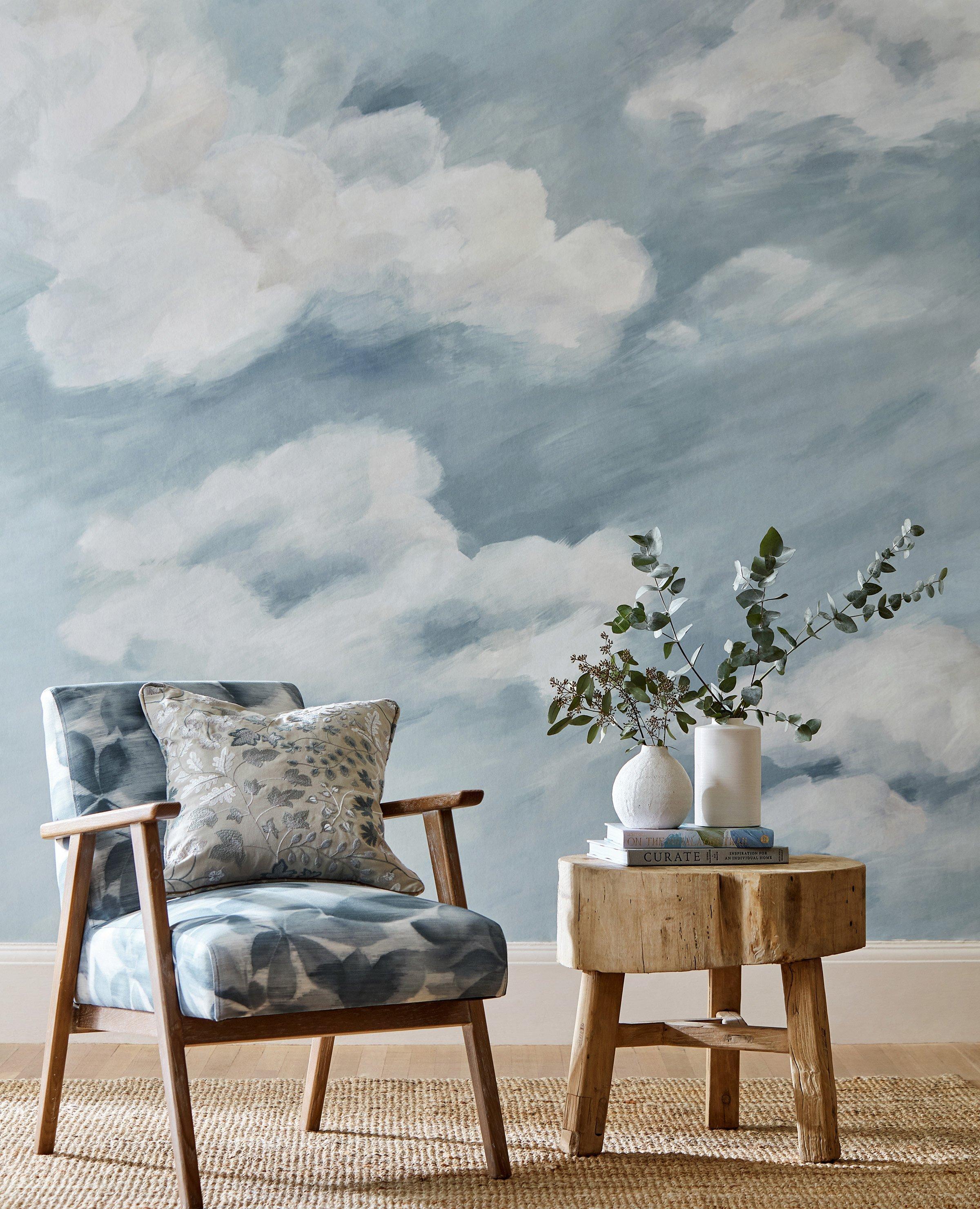 Harlequin blue cloud like wallpaper with a reading chair and a coffee table infront of the wall