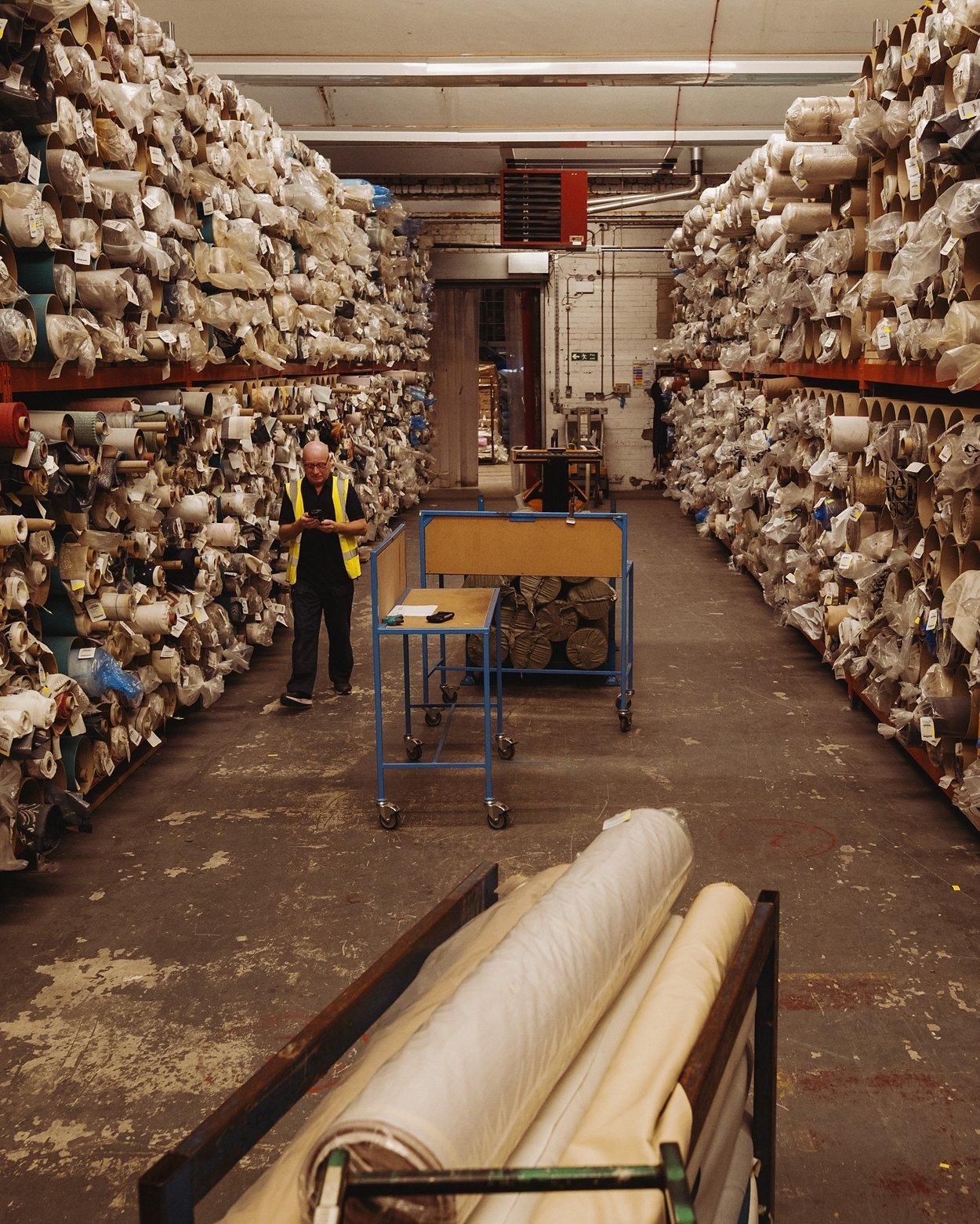 Herbert Parkinson - Worker with hundreds of rolls of fabric around him