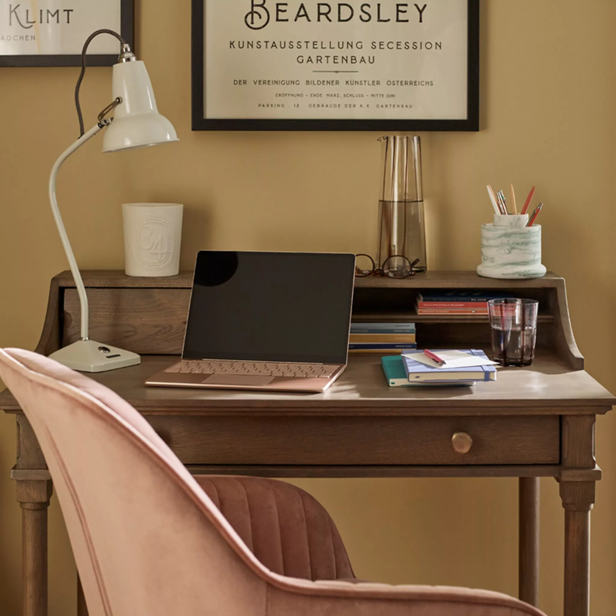 Wooden desk with laptop and pink office chair 