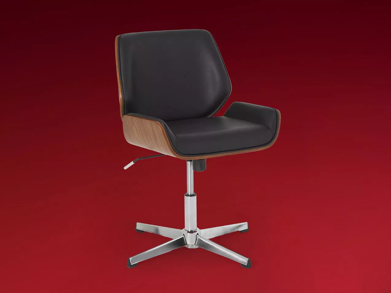 Modern black leather swivel office chair with wooden sides and chrome base on a red background