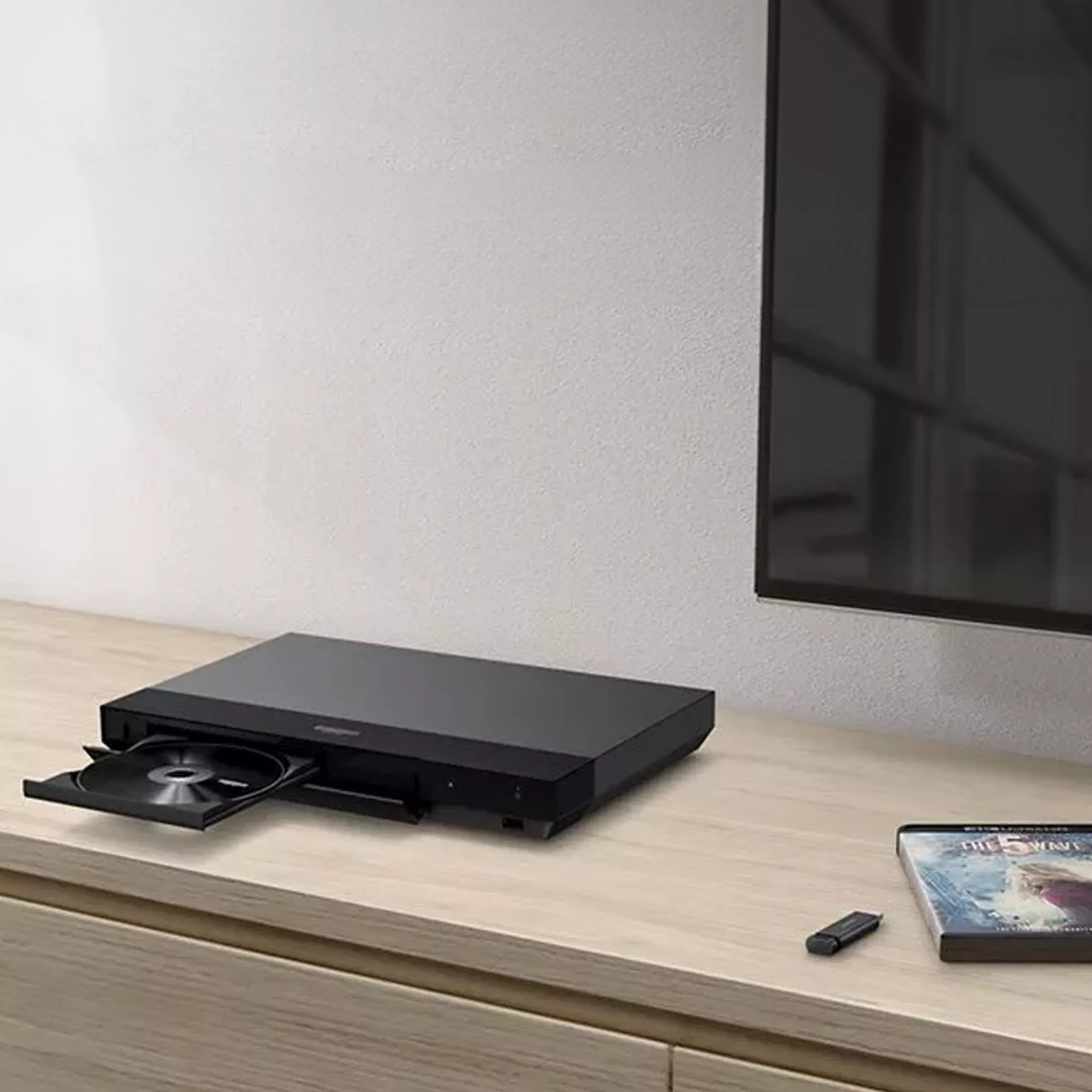 DVD player on TV stand beside a TV