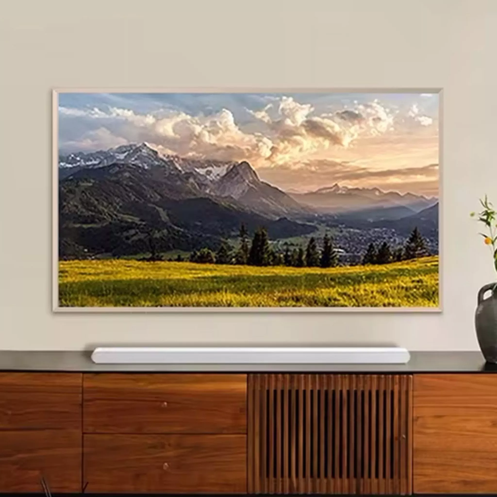White soundbar on wooden sideboard, under a wall mounted TV 