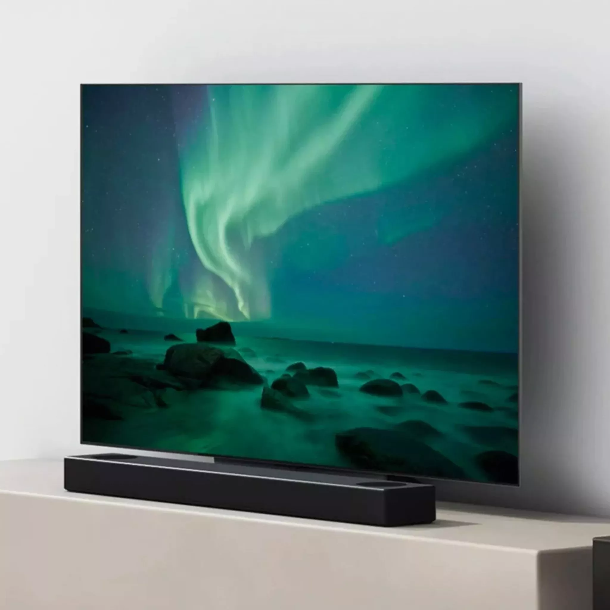 Black soundbar infront of TV on a TV stand 