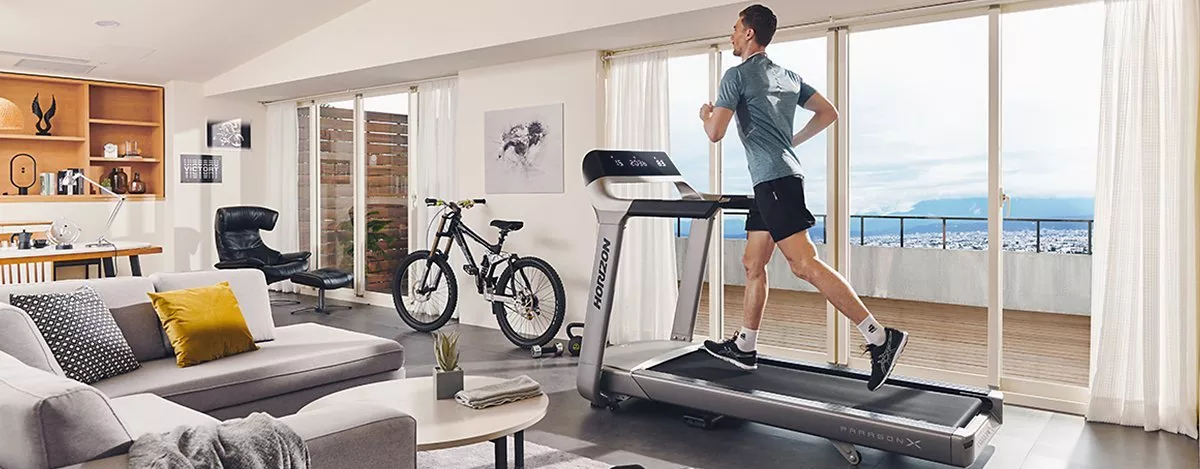 man exercising on a treadmill in his living room