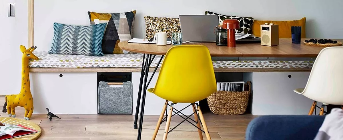 Wooden table with a laptop on it and a yellow chair