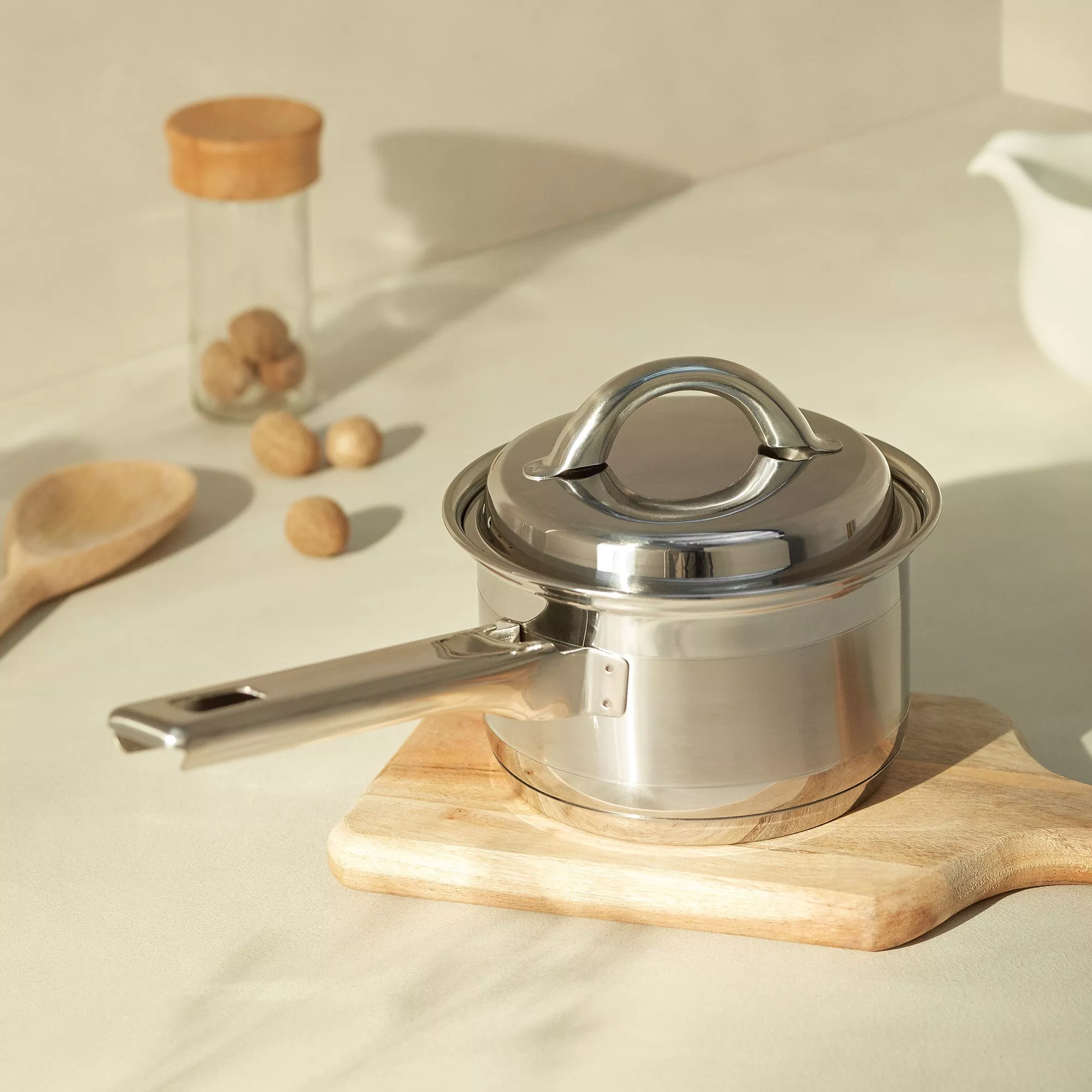 Non-stick cookware set with saucepans, stockpot and frying pan displayed on a modern kitchen worktop