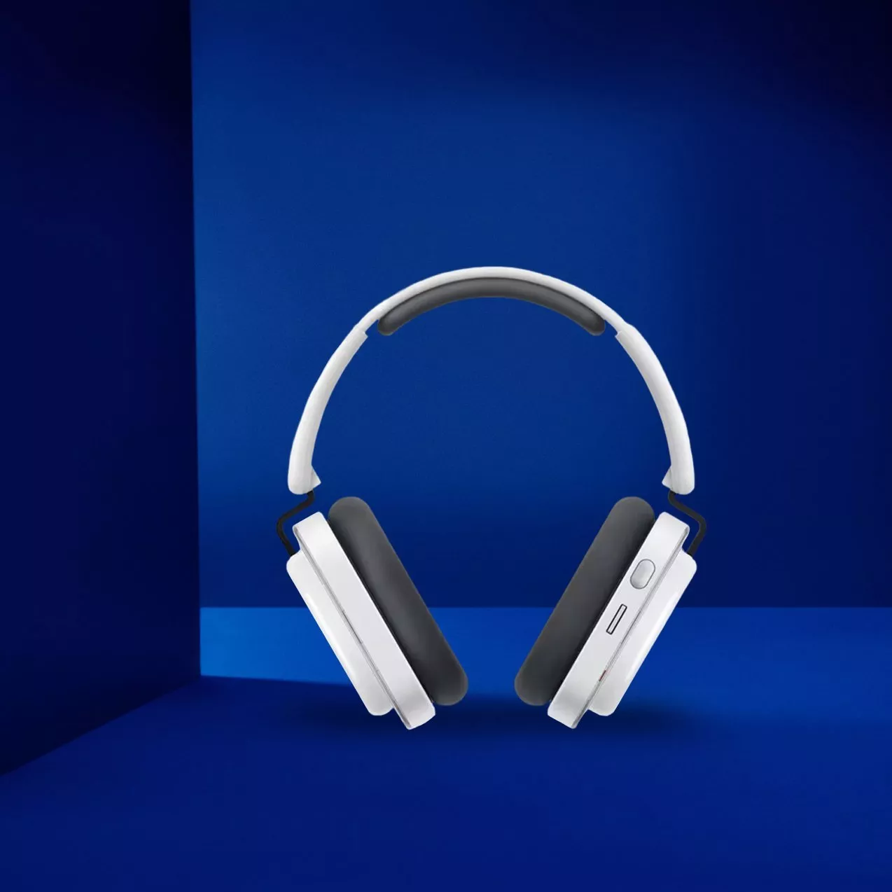 White wireless over-ear headphones with black ear cushions on a blue background, modern audio gadget product shot
