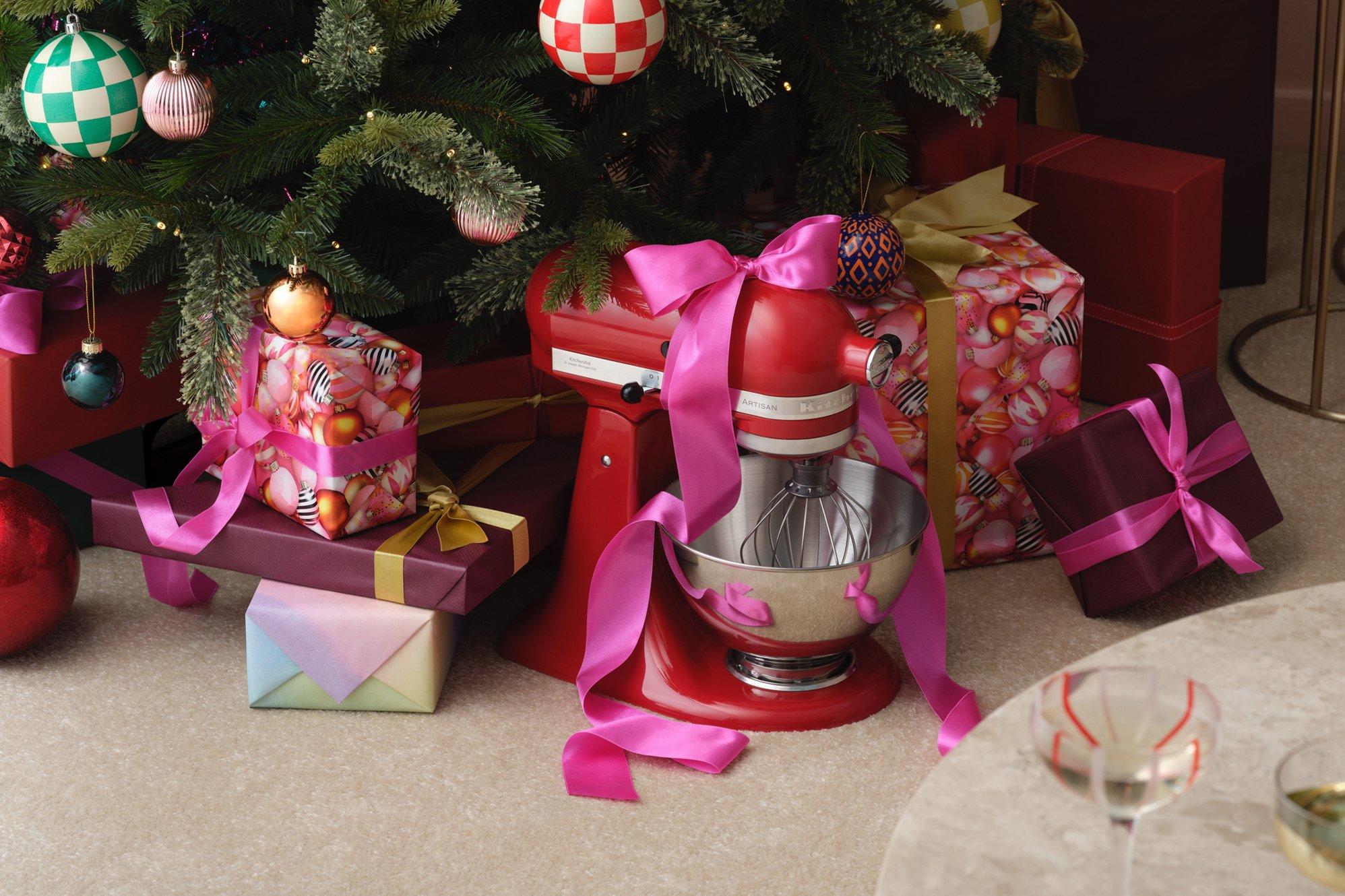 Image of a KitchenAid with a pink bow on it under the tree