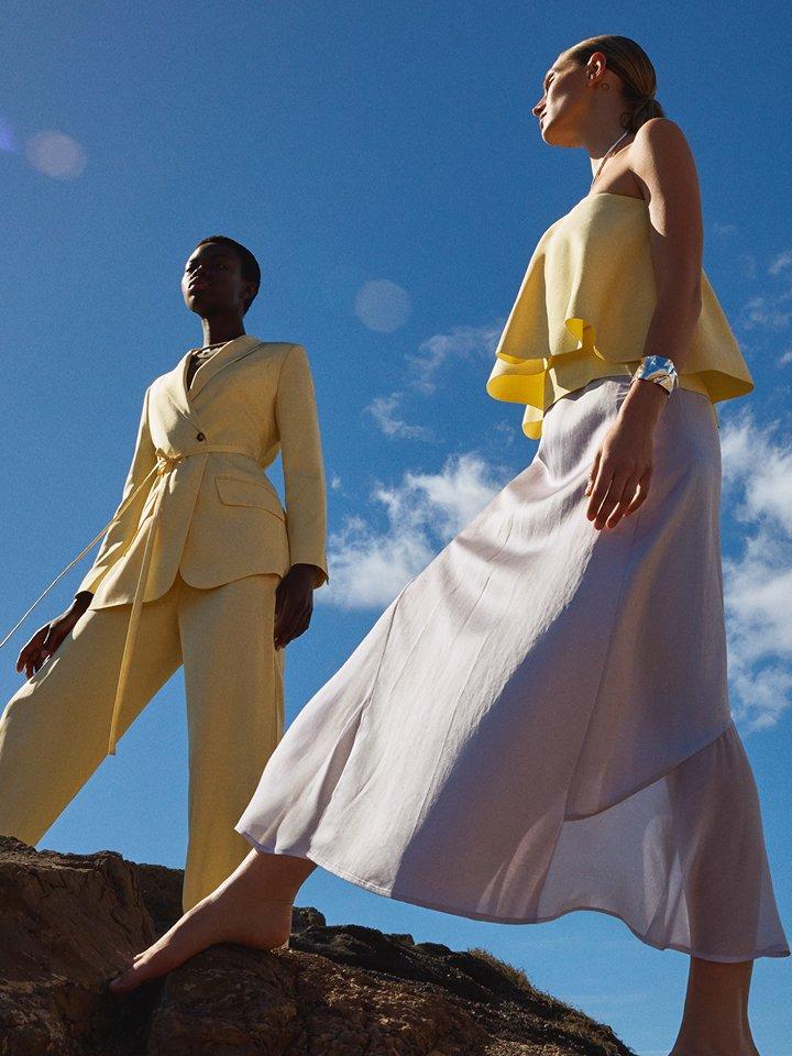 Two female wearing a yellow occasionwear suit co-rd and yellow cami top with a satin silver maxi skirt