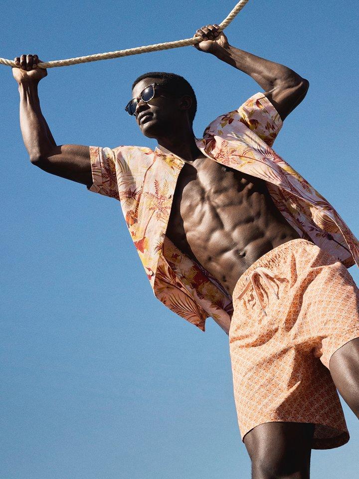 Male model wearing swimshorts and a linen shirt