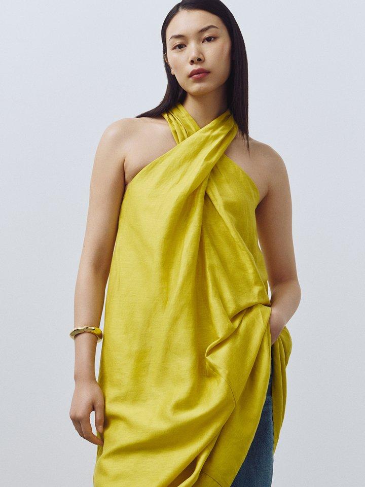 Two female models wearing linen summer dresses in bright colours