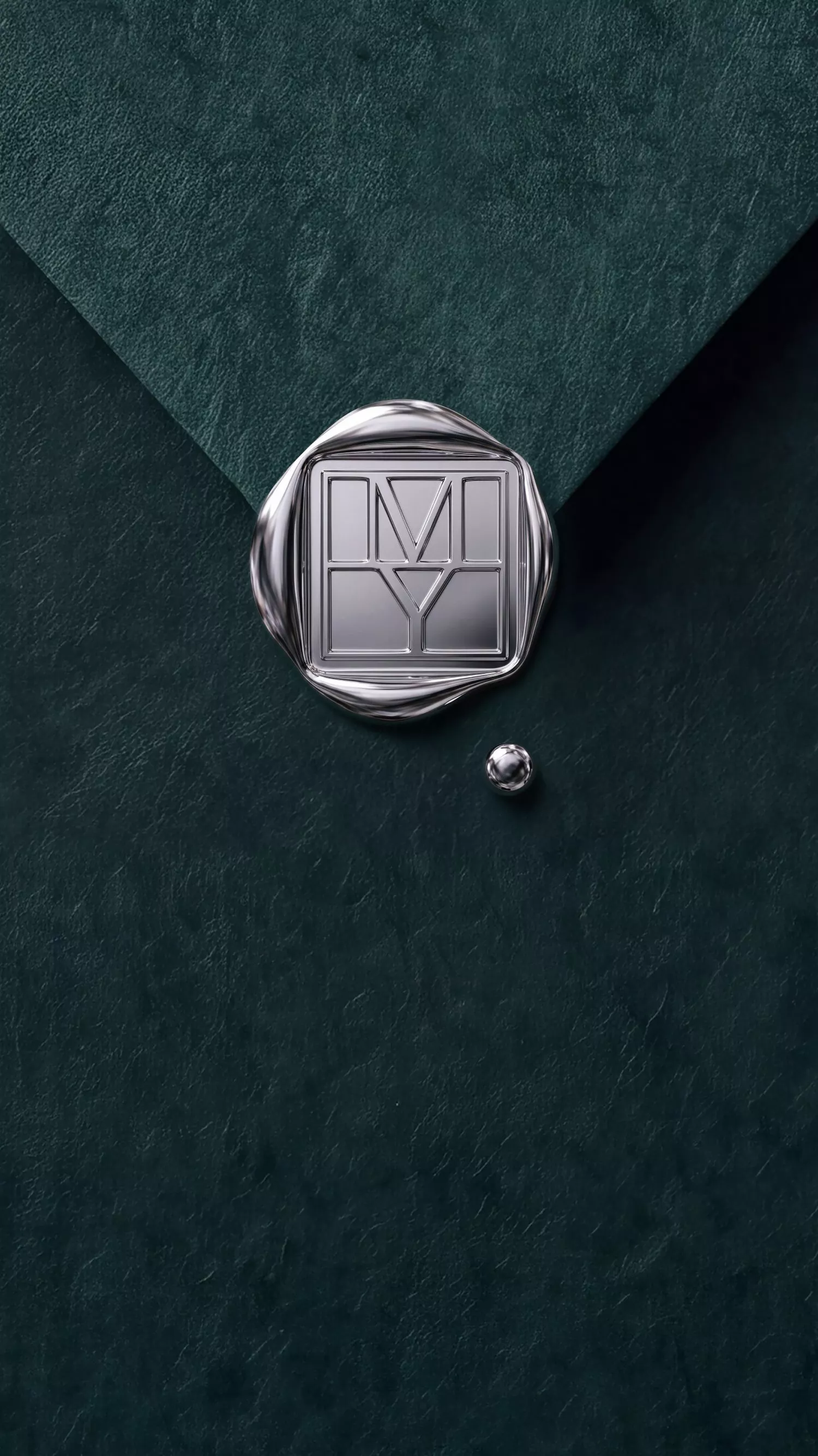 Silver wax seal with MY monogram on dark green textured paper, luxury branding and stationery detail