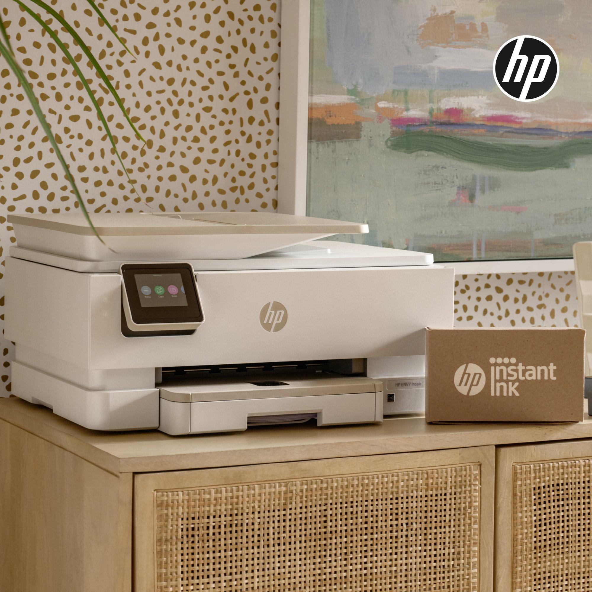 White HP printer and an HP Instant Ink box on a wooden cabinet.