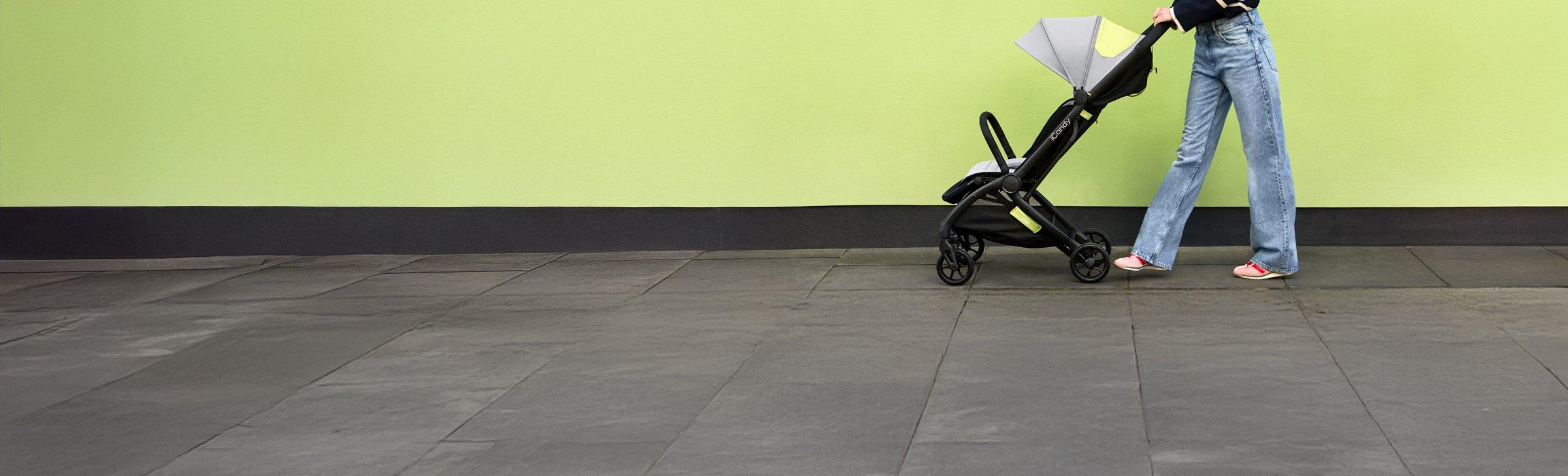 women pushing a buggy infront of a lime green wall