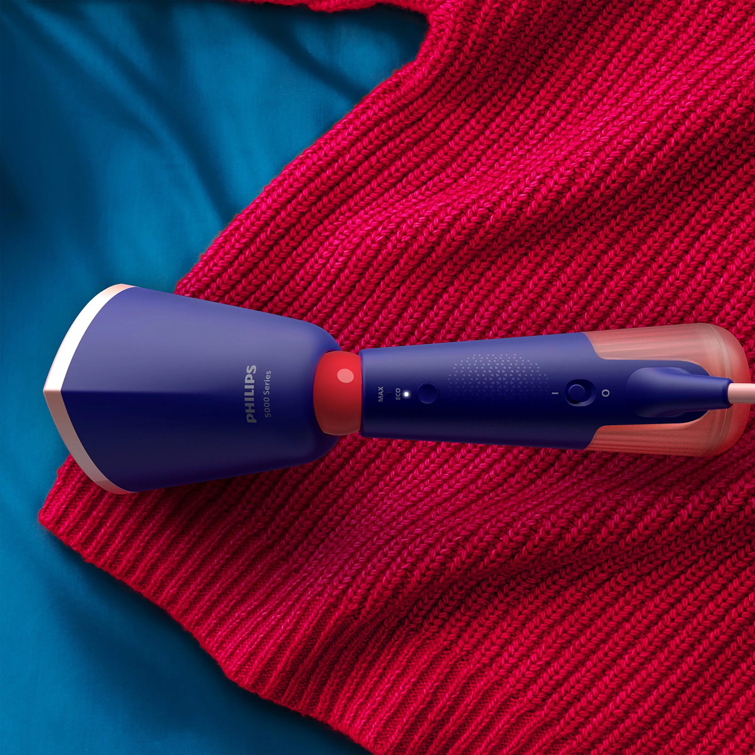 Purple Philips steam cleaner steaming a red jumper 