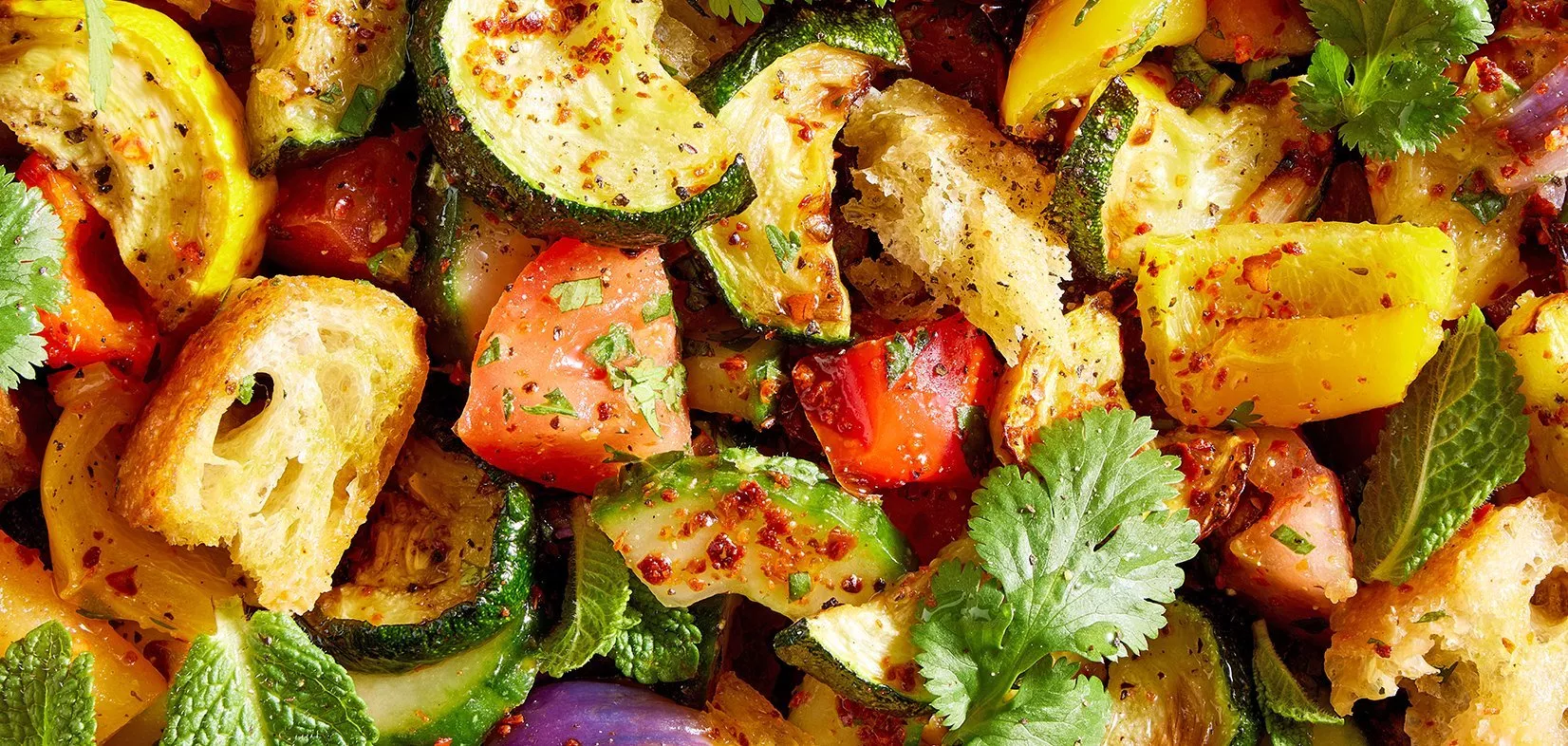 Close-up of roasted vegetable panzanella salad with courgette, peppers, tomatoes, herbs and crusty bread cubes