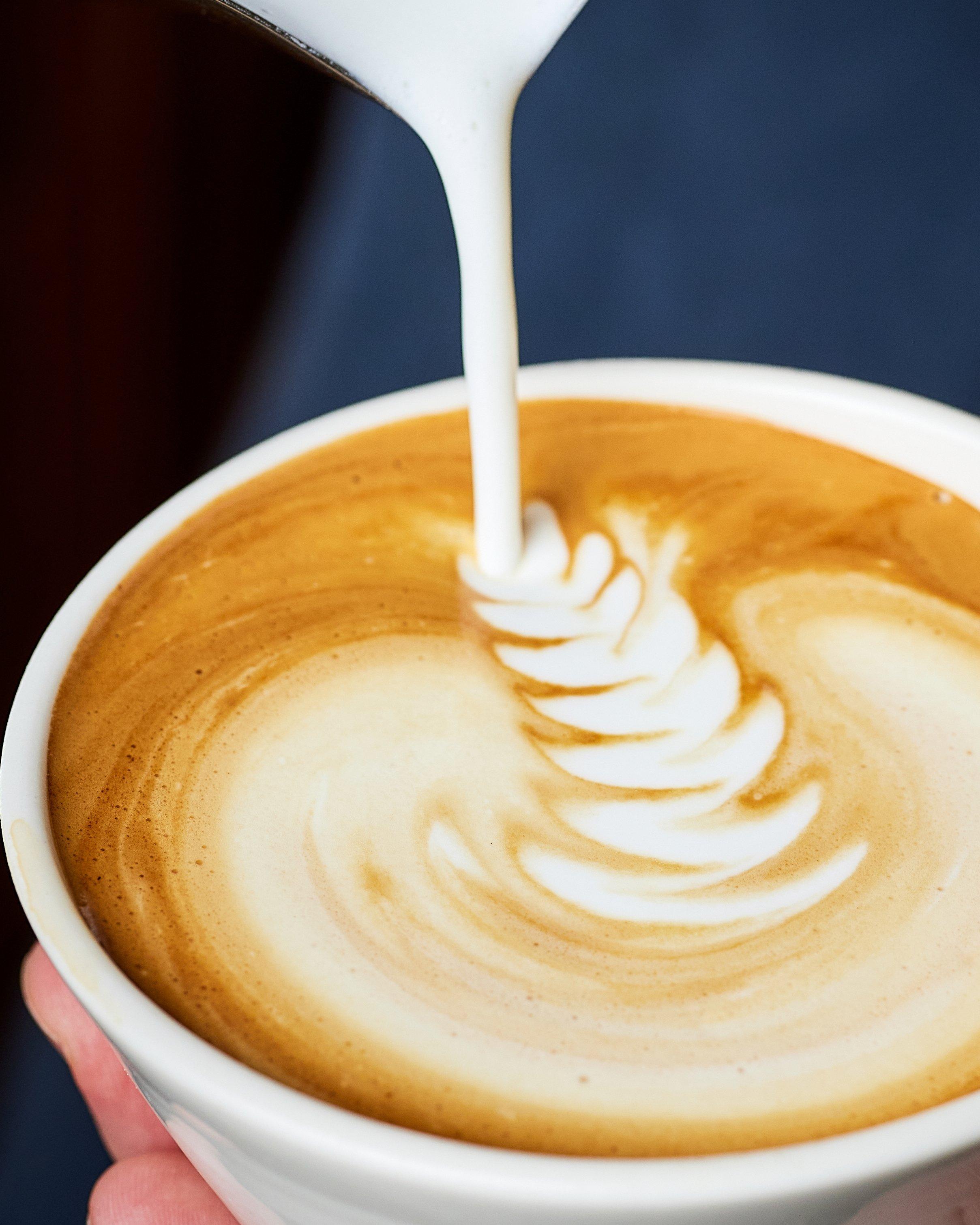 close up of a latte being poured