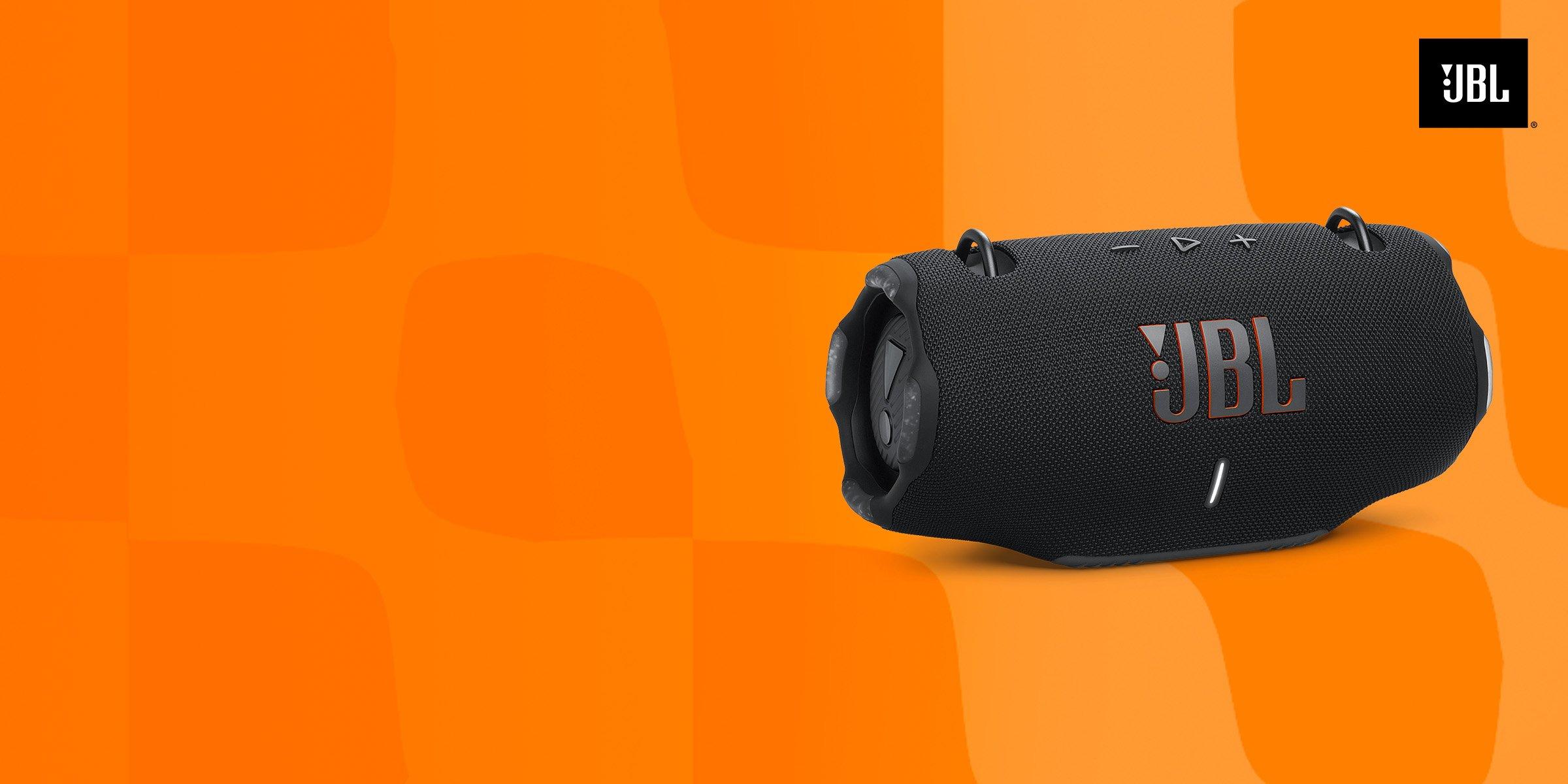 A black JBL portable speaker on an orange background.