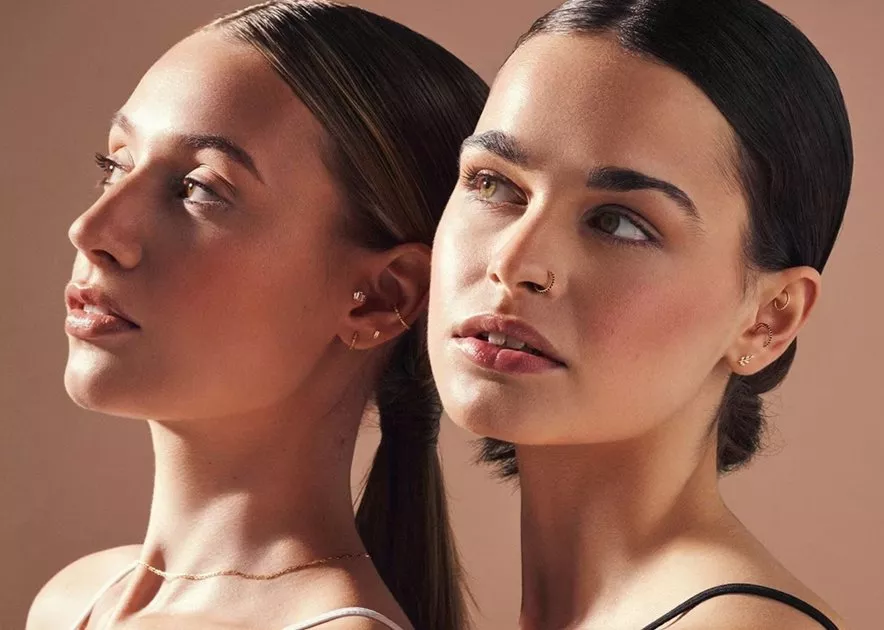 two woman with ear and nose piercings