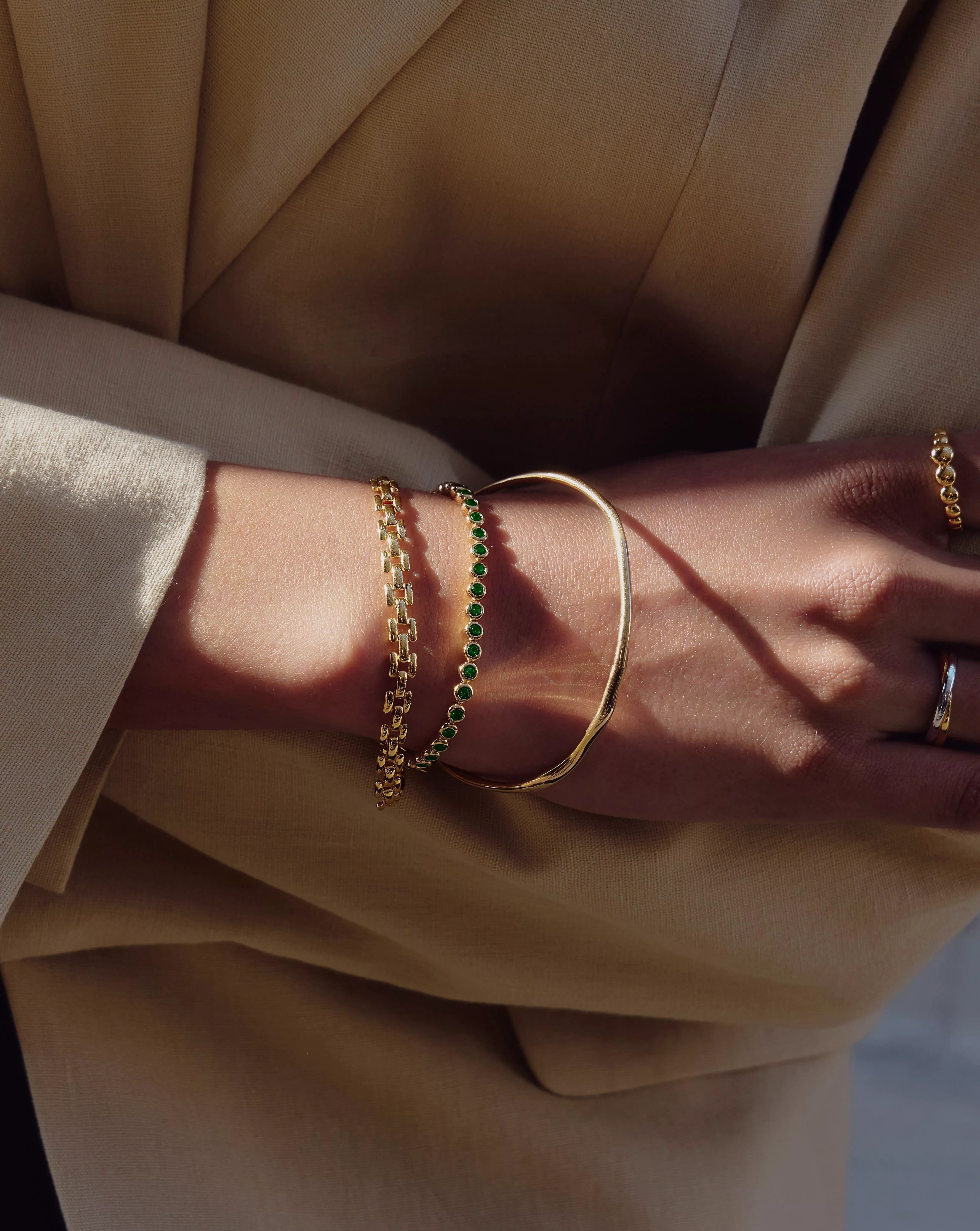 Person wearing 3 gold necklaces