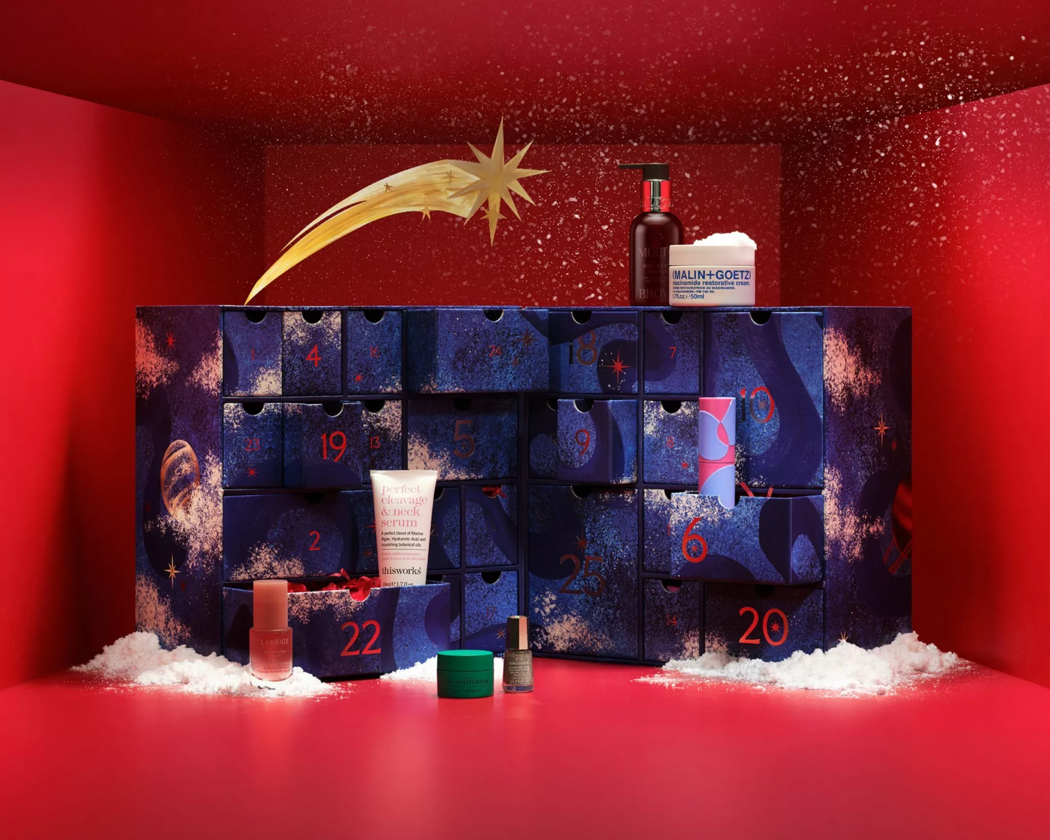 Blue beauty advent calendar gift box with numbered drawers and skincare products on a deep blue studio set