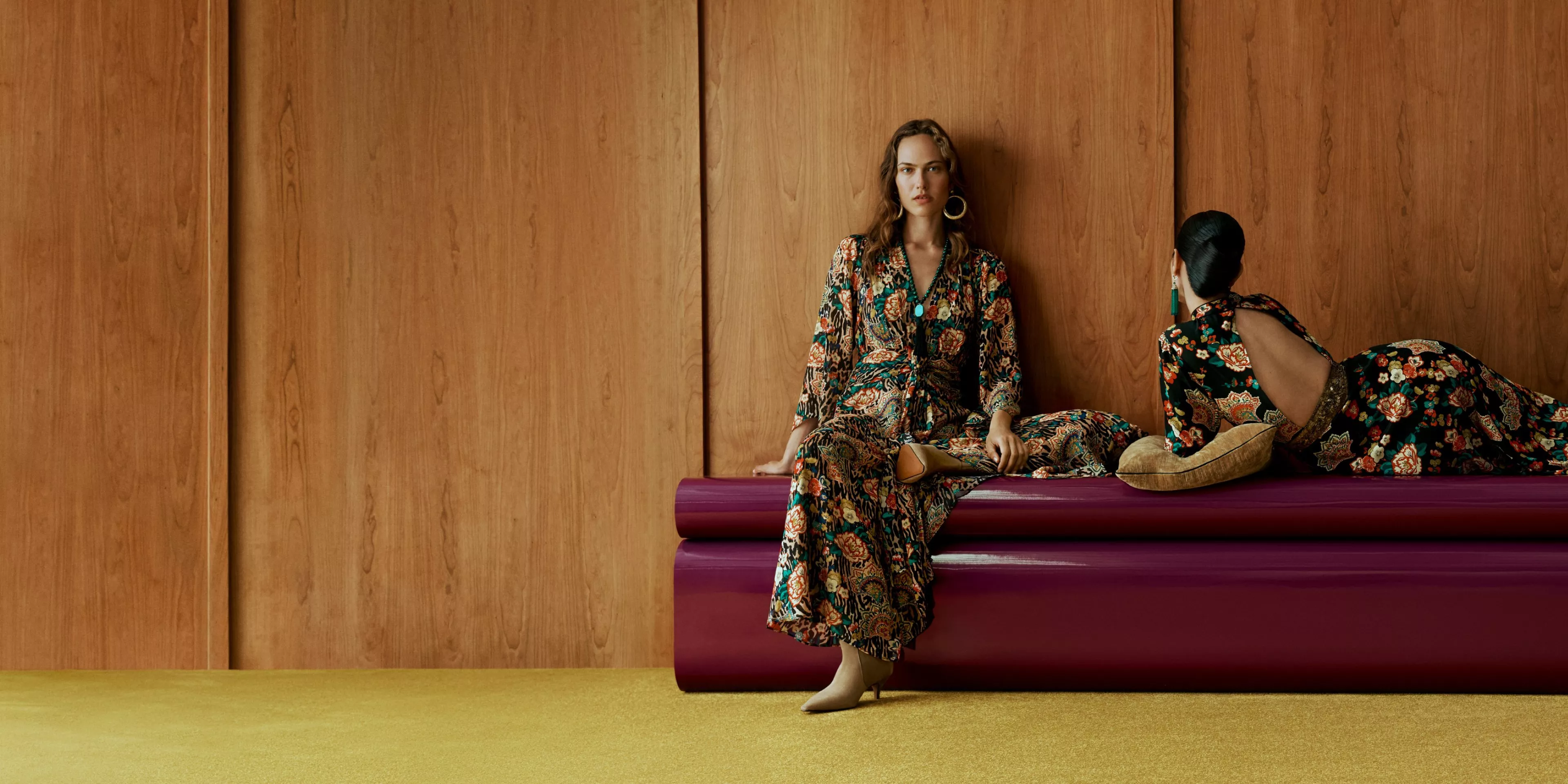two women on a red seat. 