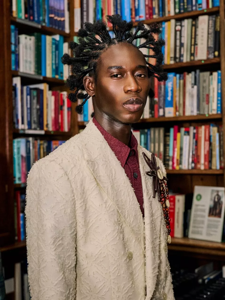 close up of a model in labrum clothes  in front of a bookcase 
