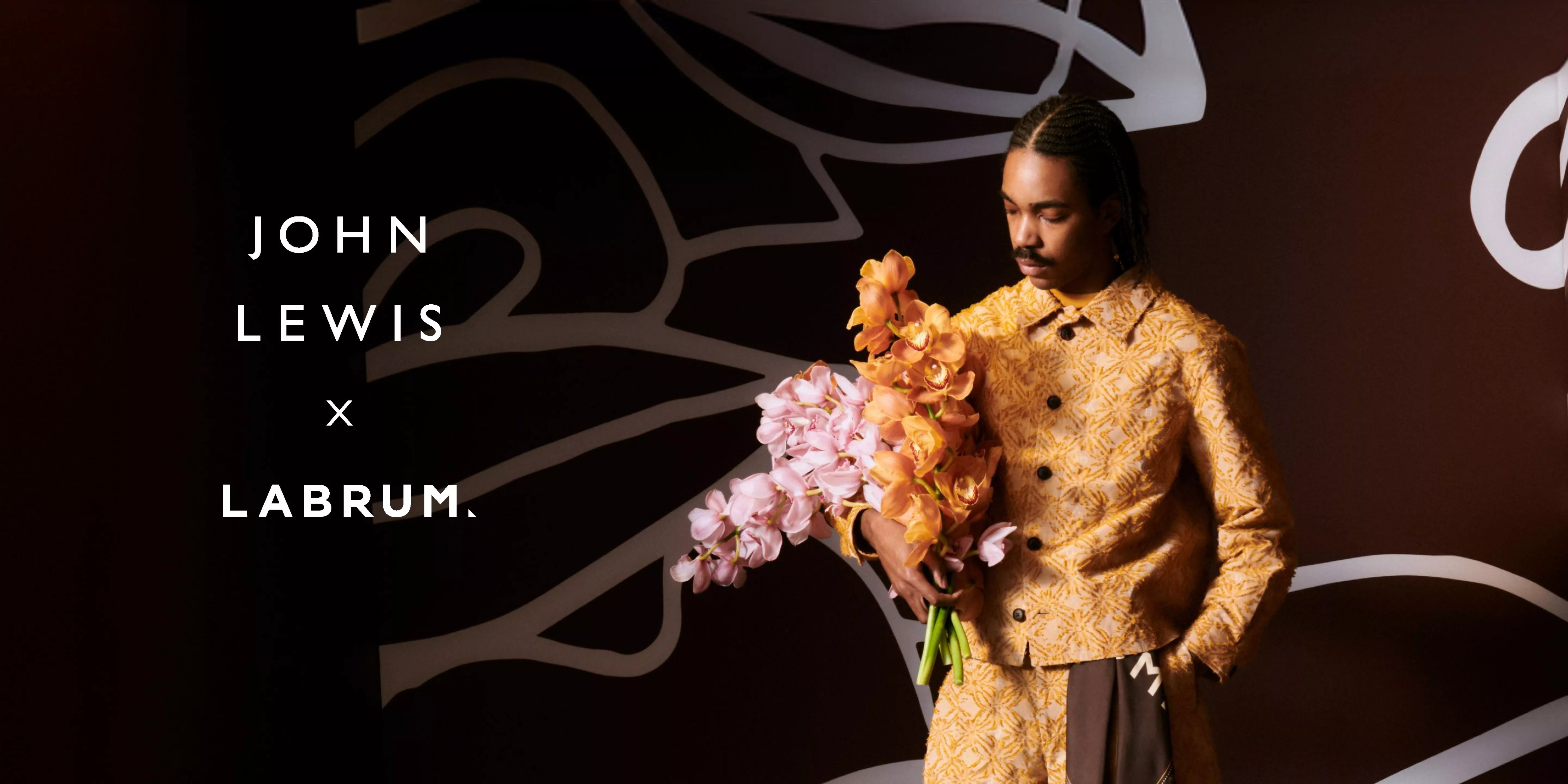 male model wearing a yellow labrum suit holding flowers