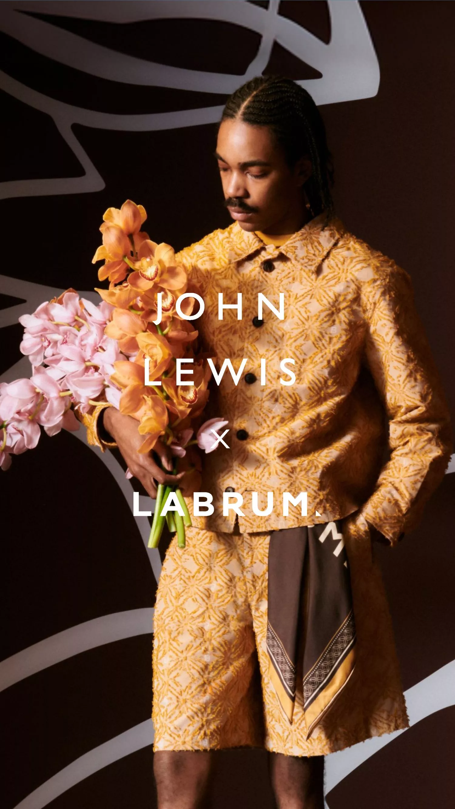 male model wearing a yellow labrum suit holding flowers