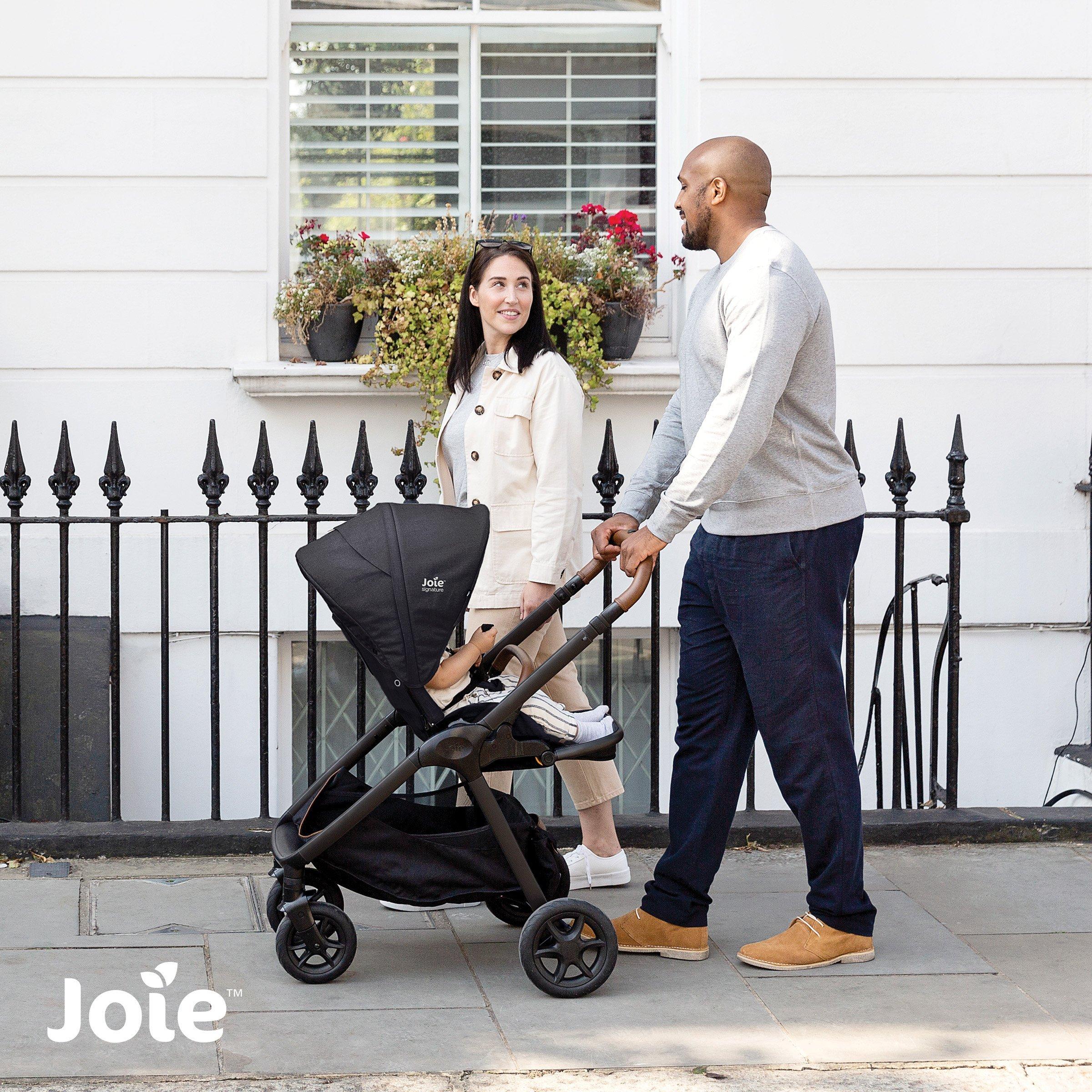 Parents strolling their baby down a city street