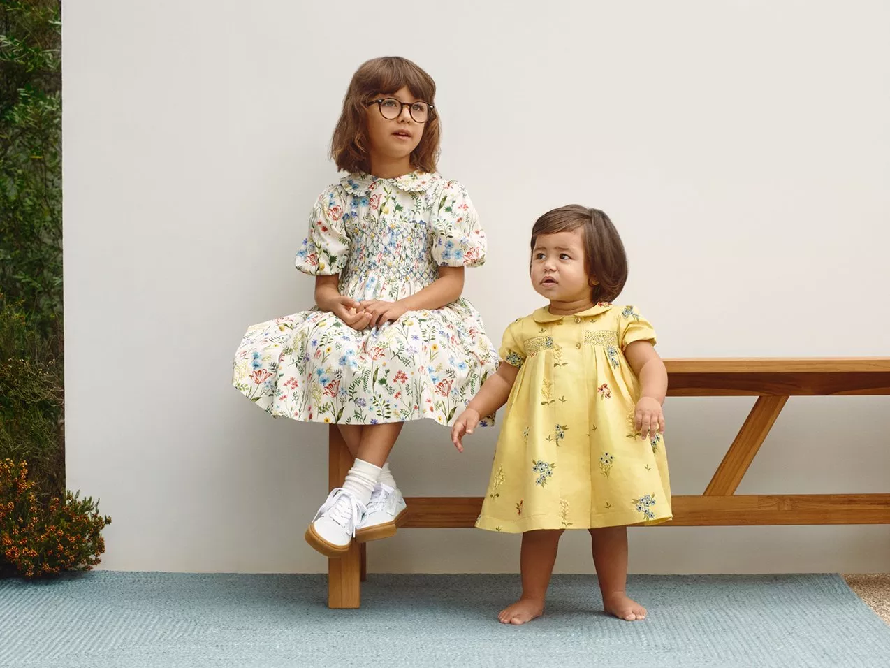 Girl in floral wedding outfit. Toddler in yellow dress wedding outfit