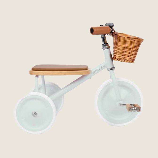 Kids' tricycle with white frame, wooden seat, and front basket