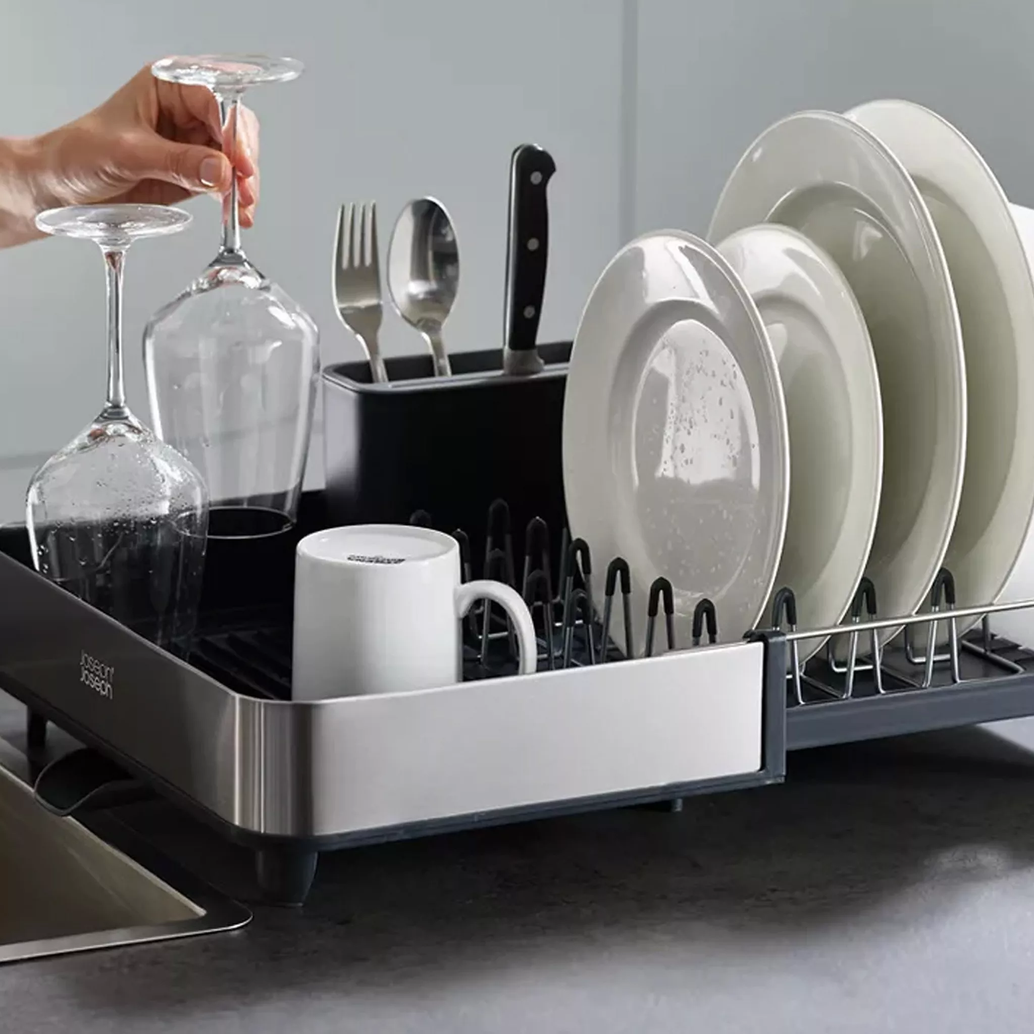 Selection of plates, glasses and cutlery on a dish drainer