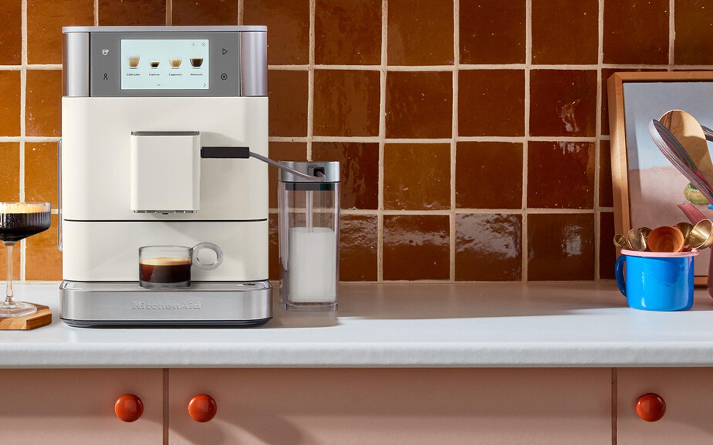 Image of the kitchenaid coffee machine sitting on a kitchen side with an espresso martini next to it