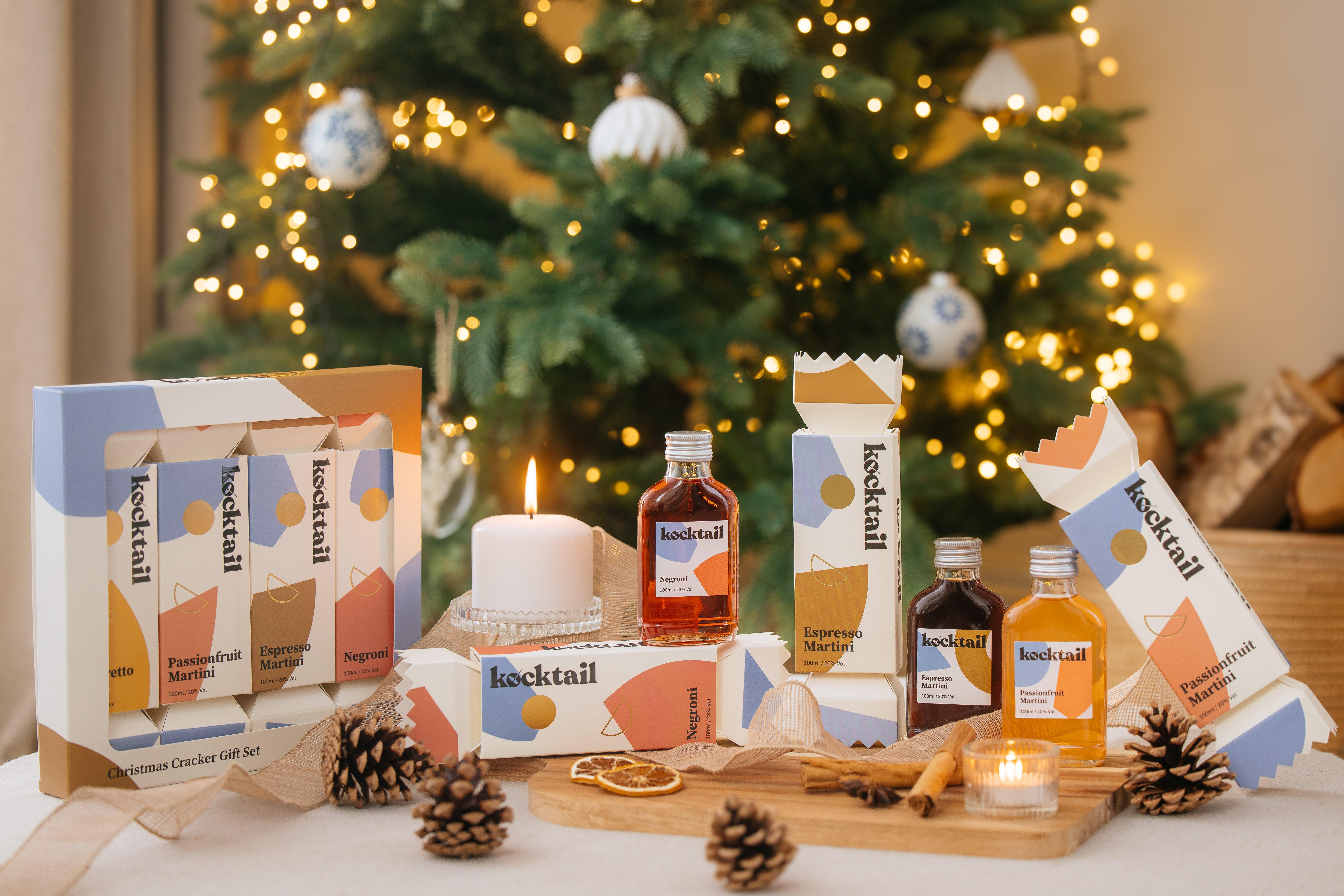 various bottles of kocktail drinks on a table, with a christmas tree behind