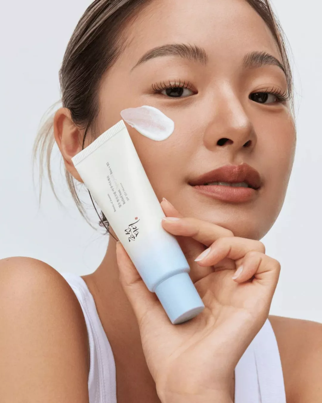 Stacked Beauty of Joseon skincare serum dropper bottles with spills, showcasing Korean beauty products on white background