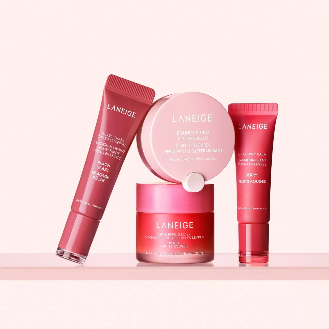 Laneige lip care set with lip sleeping mask, lip treatment, tinted serum and lip glowy balm on pink background