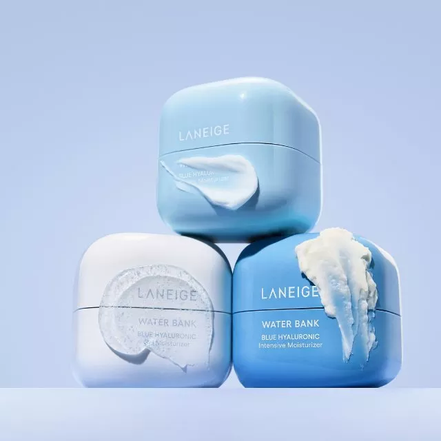 Laneige Water Bank Blue Hyaluronic moisturiser jars stacked on blue background with cream swatches on lids