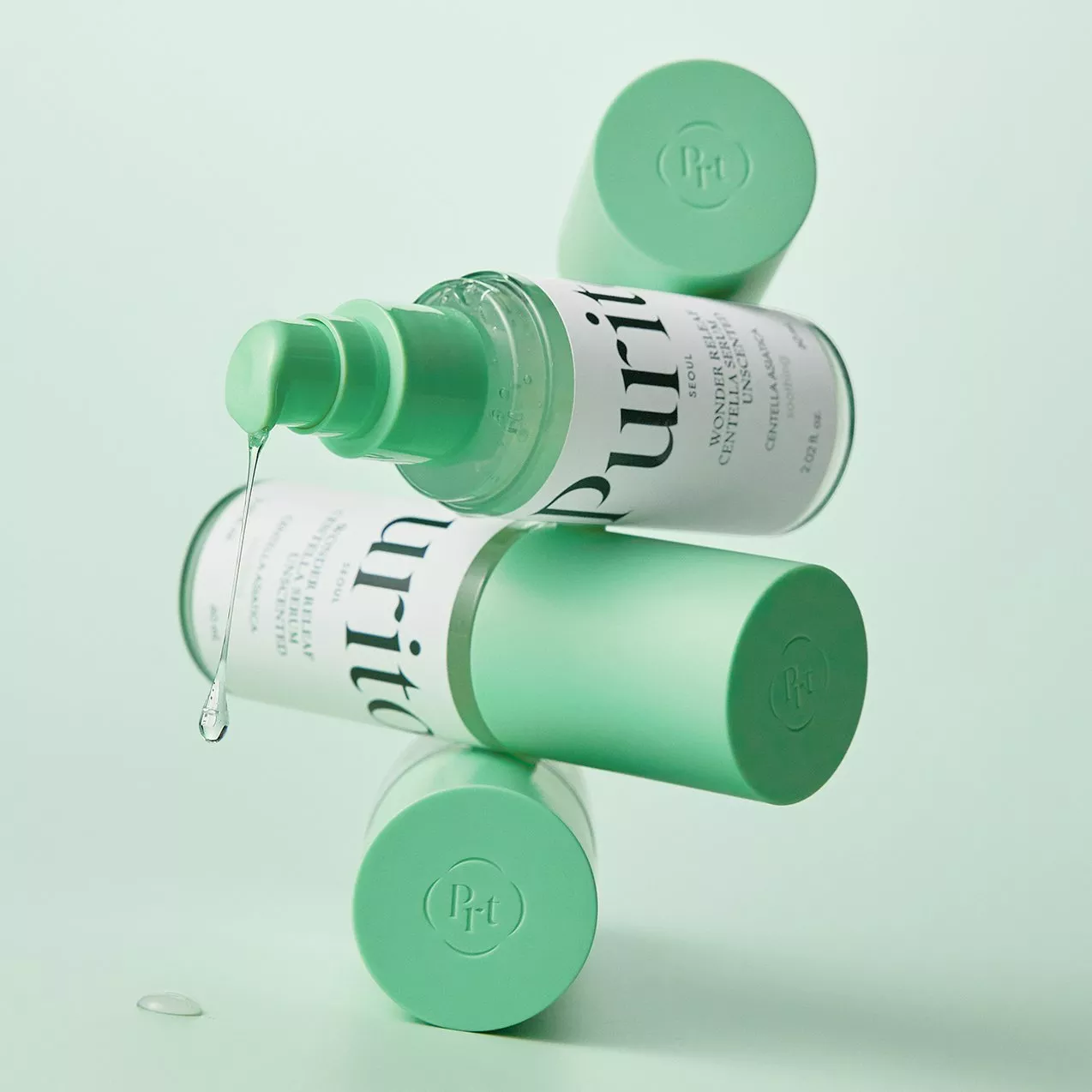 Close-up of Purito Centella Unscented Serum with green pump bottle, skincare product shot on mint background.