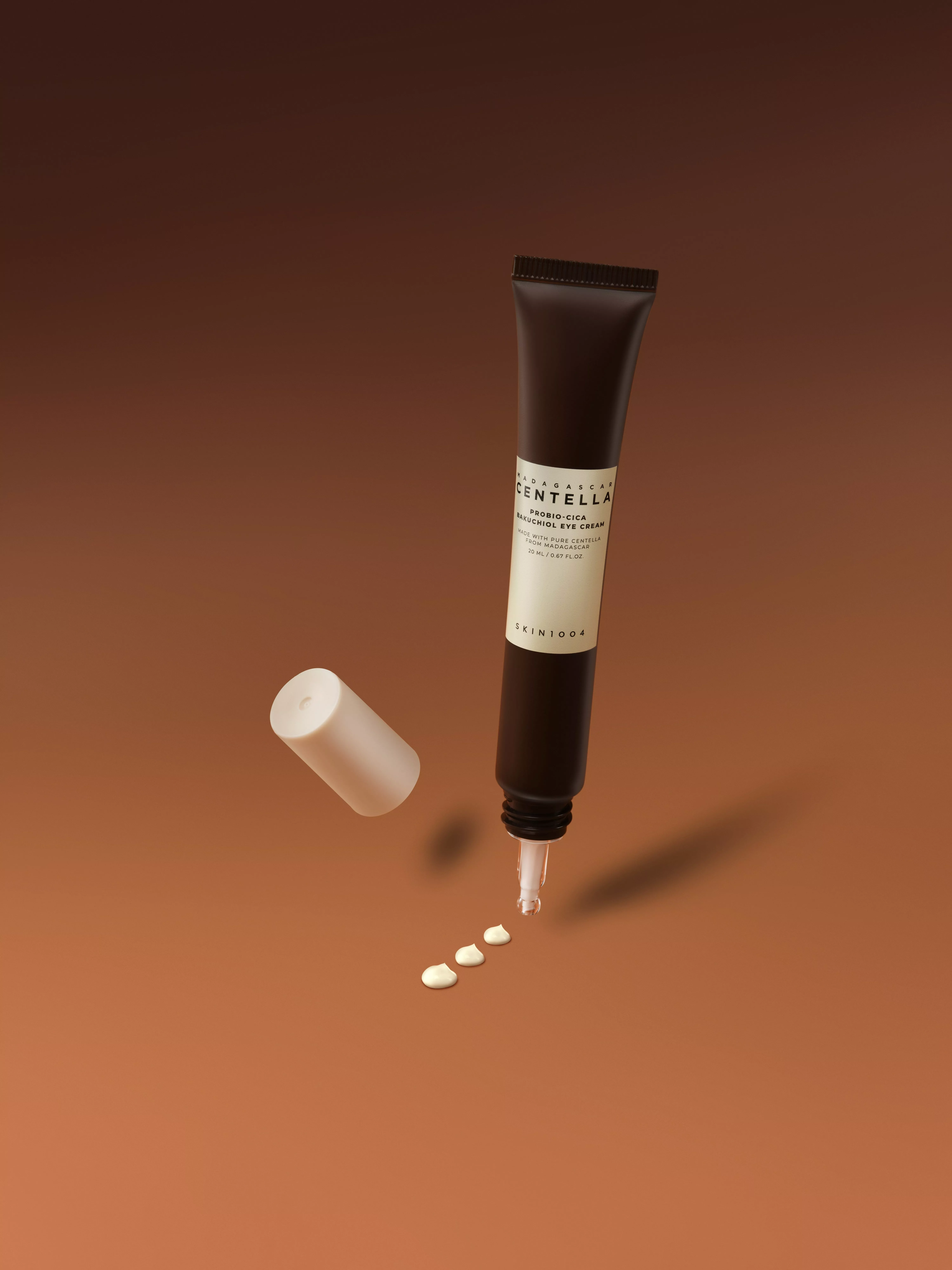 SKIN1004 Madagascar Centella Probio-Cica Bakuchiol eye cream tube with cap off, cream dots on brown backdrop